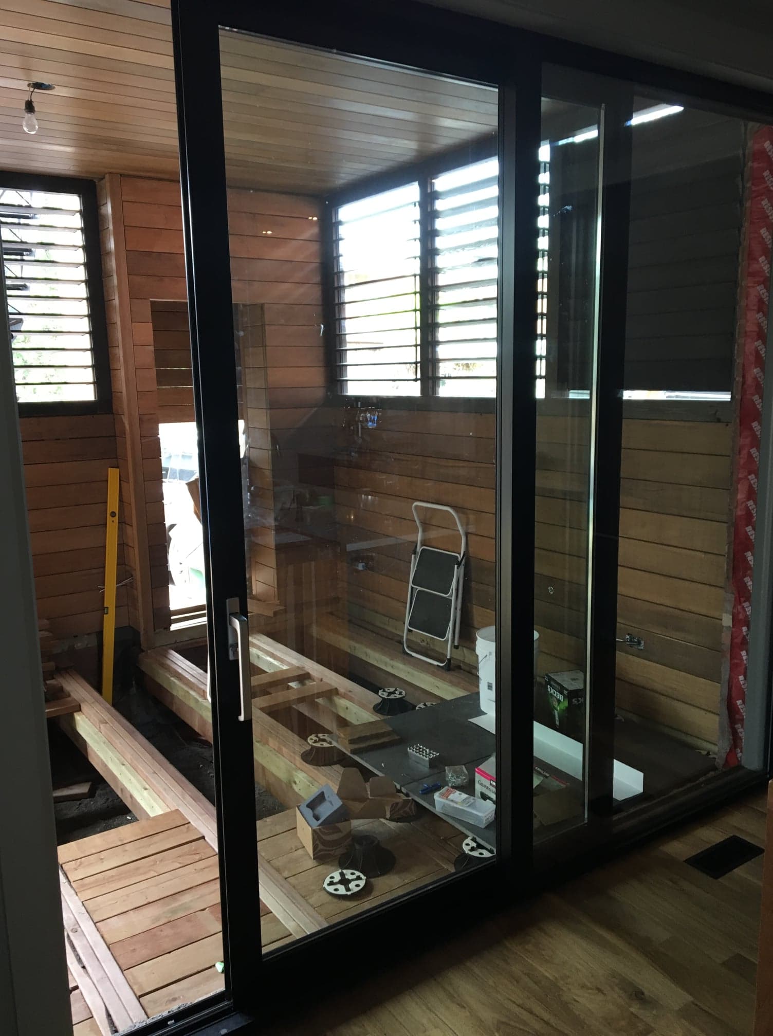 Une pièce avec beaucoup de fenêtres et de portes coulissantes en verre.