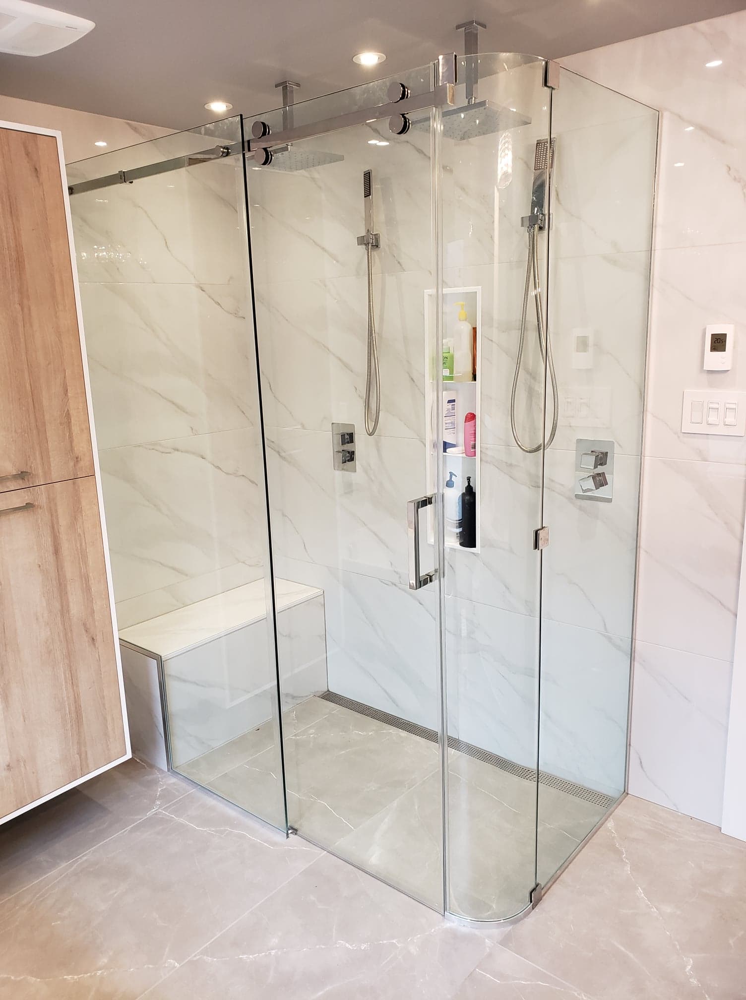 Une salle de bain avec une douche à l'italienne et un banc.