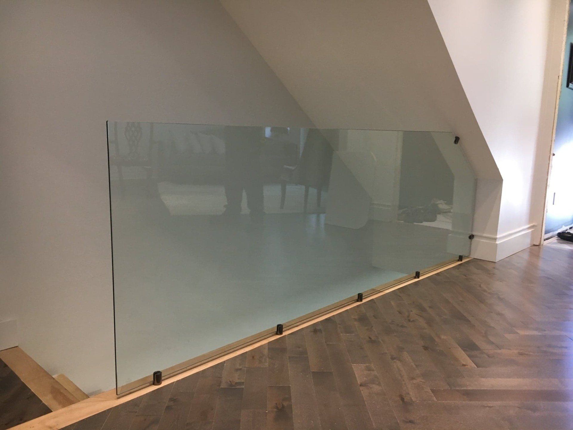 Un escalier avec une rampe en verre et une rampe en bois.