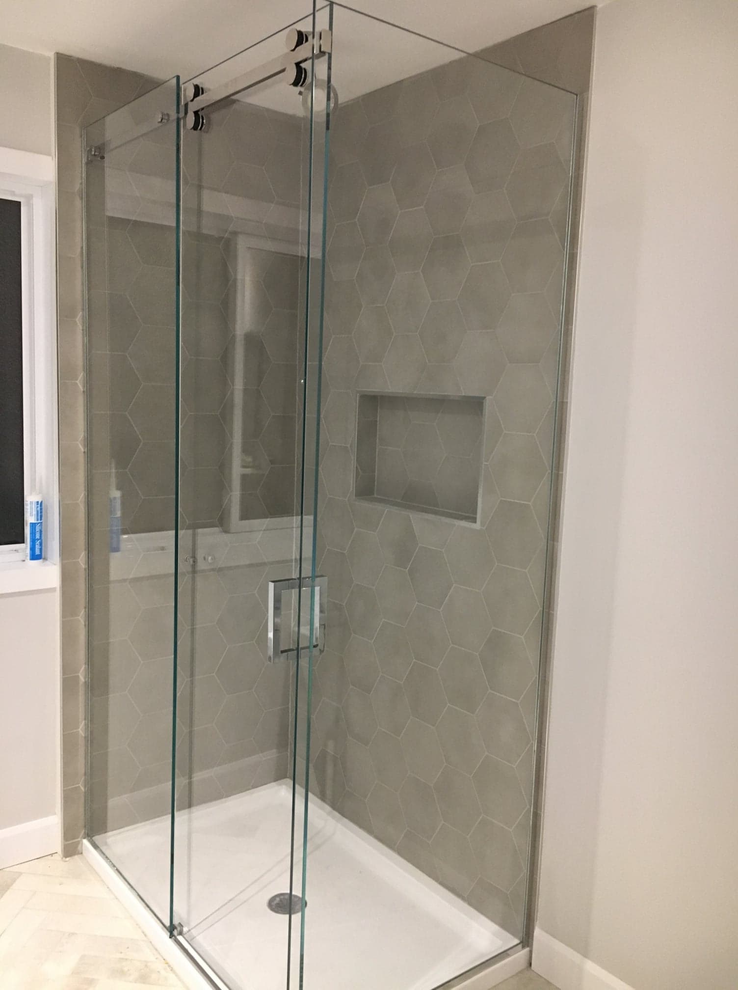 Une salle de bain avec douche à l'italienne et fenêtre.