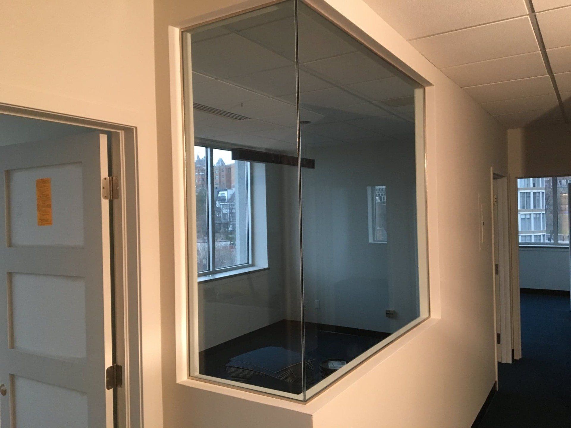 Un couloir avec une fenêtre en verre dans le coin