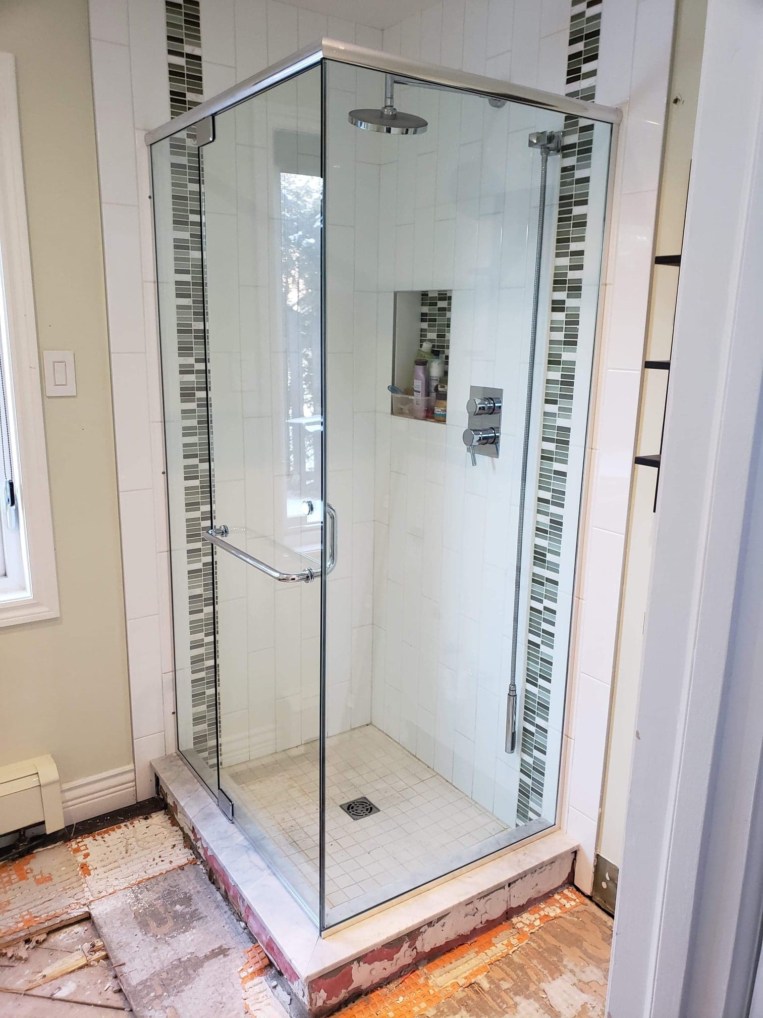 Une salle de bain avec une cabine de douche et une fenêtre.