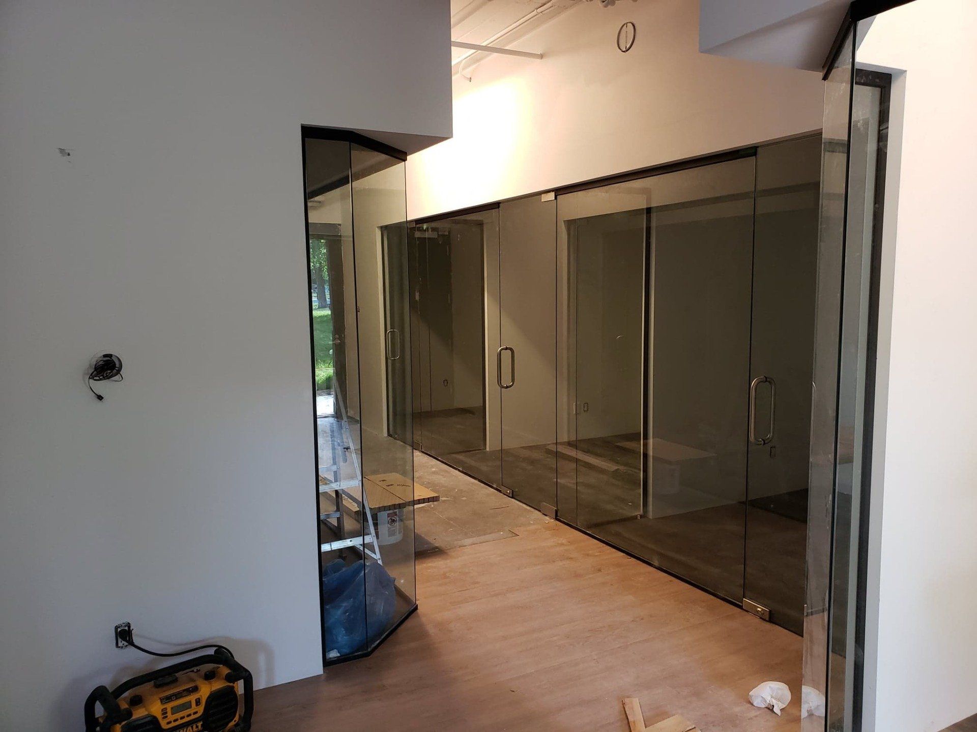 Une pièce avec beaucoup de portes vitrées et une radio au sol.