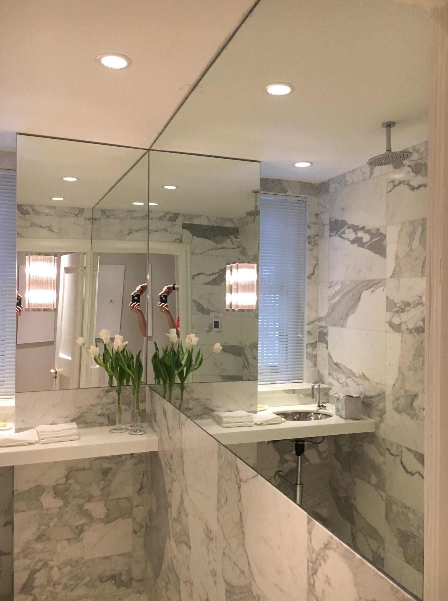 Une salle de bain avec des murs en marbre et un grand miroir