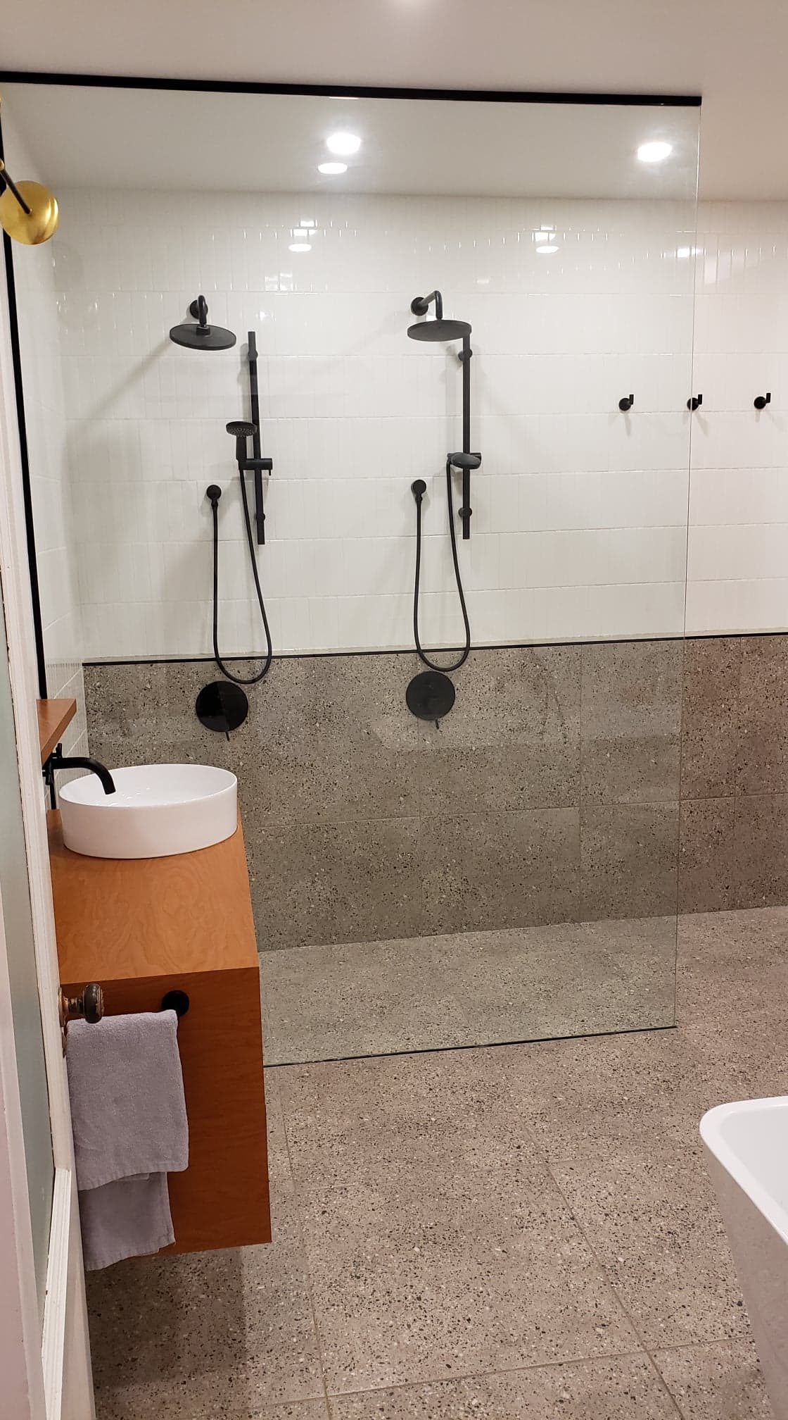 Une salle de bain avec deux douches, un lavabo et une baignoire.