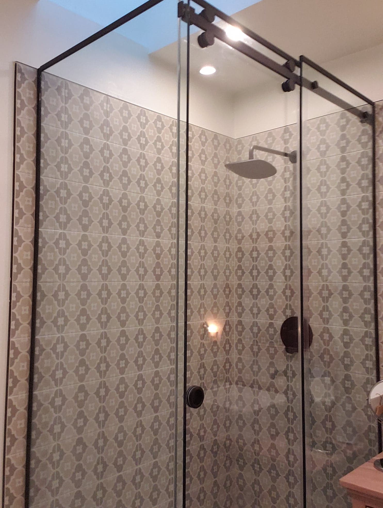 Une salle de bain avec une porte de douche coulissante en verre et une pomme de douche.