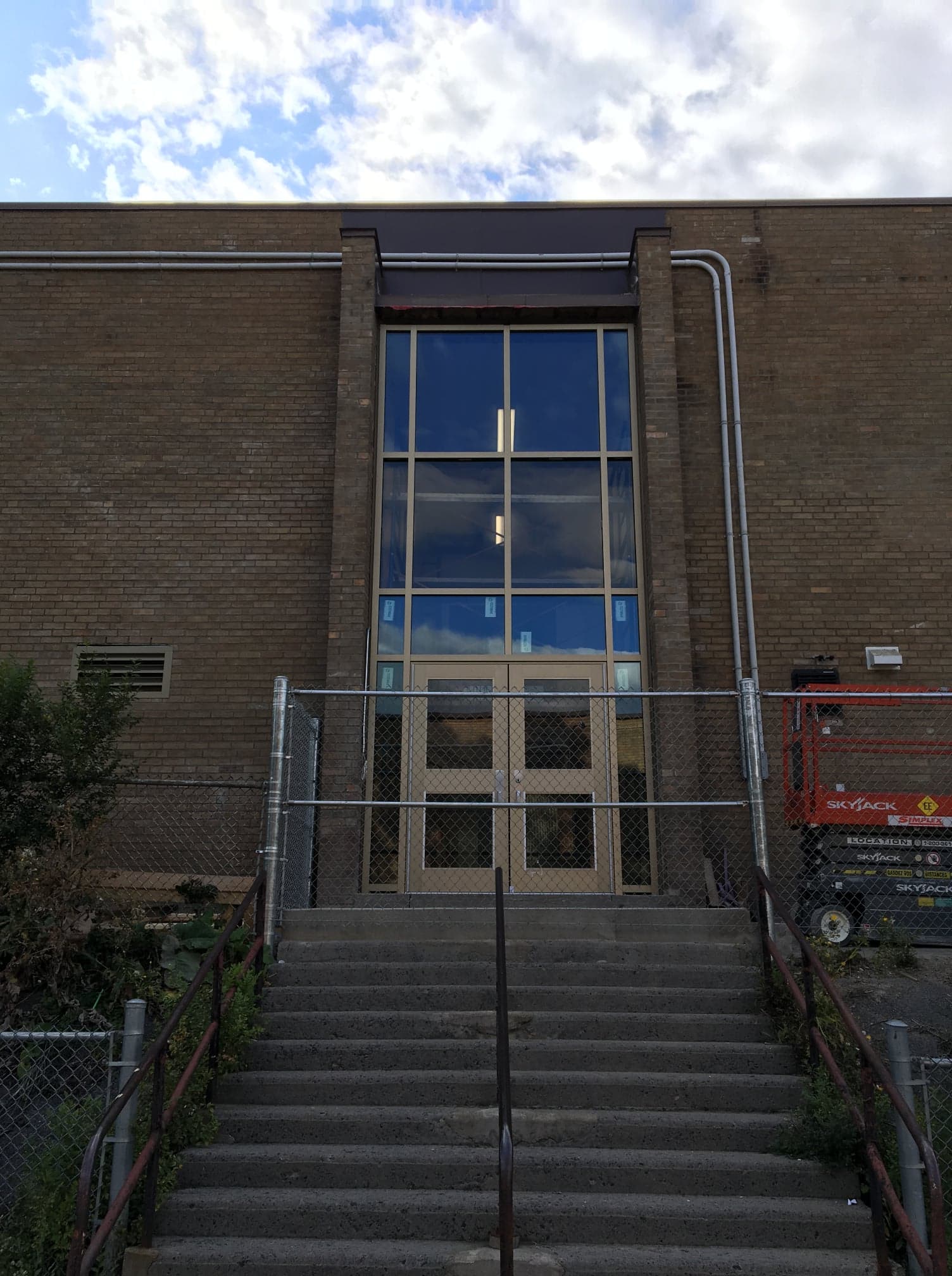 A brick building with stairs leading up to the door