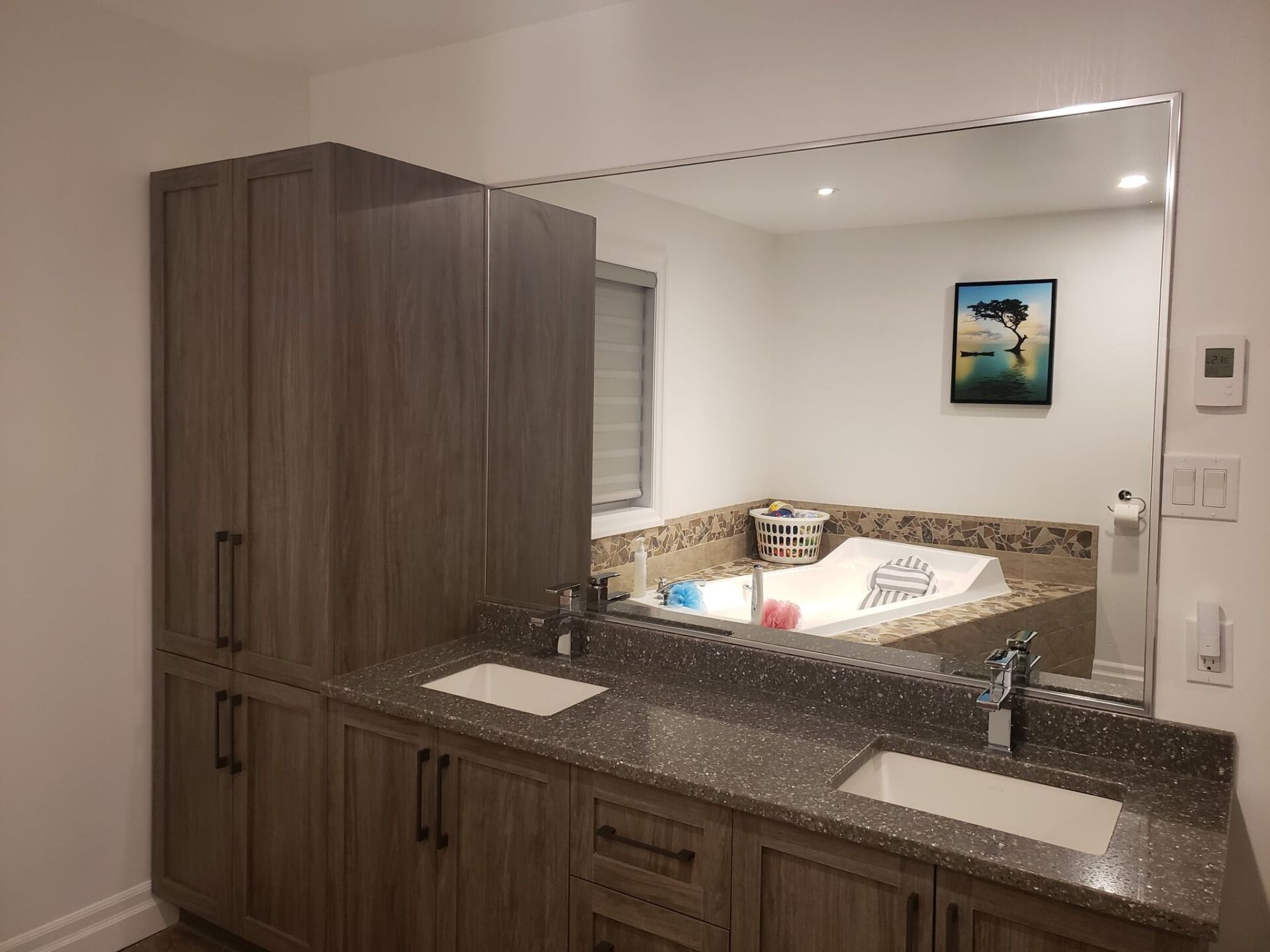 Une salle de bain avec deux lavabos et un grand miroir.