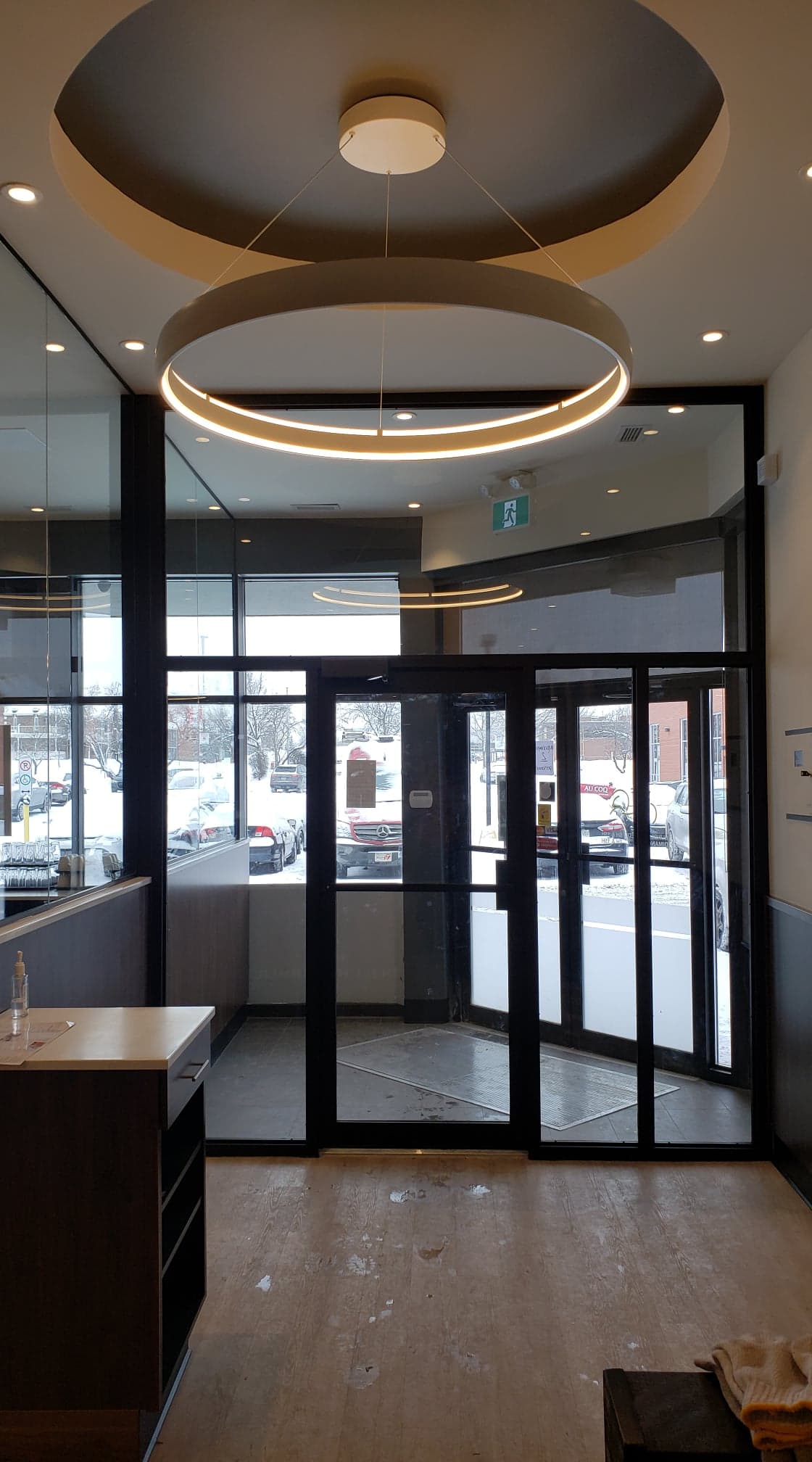 A lobby with a large glass door and a ceiling light.