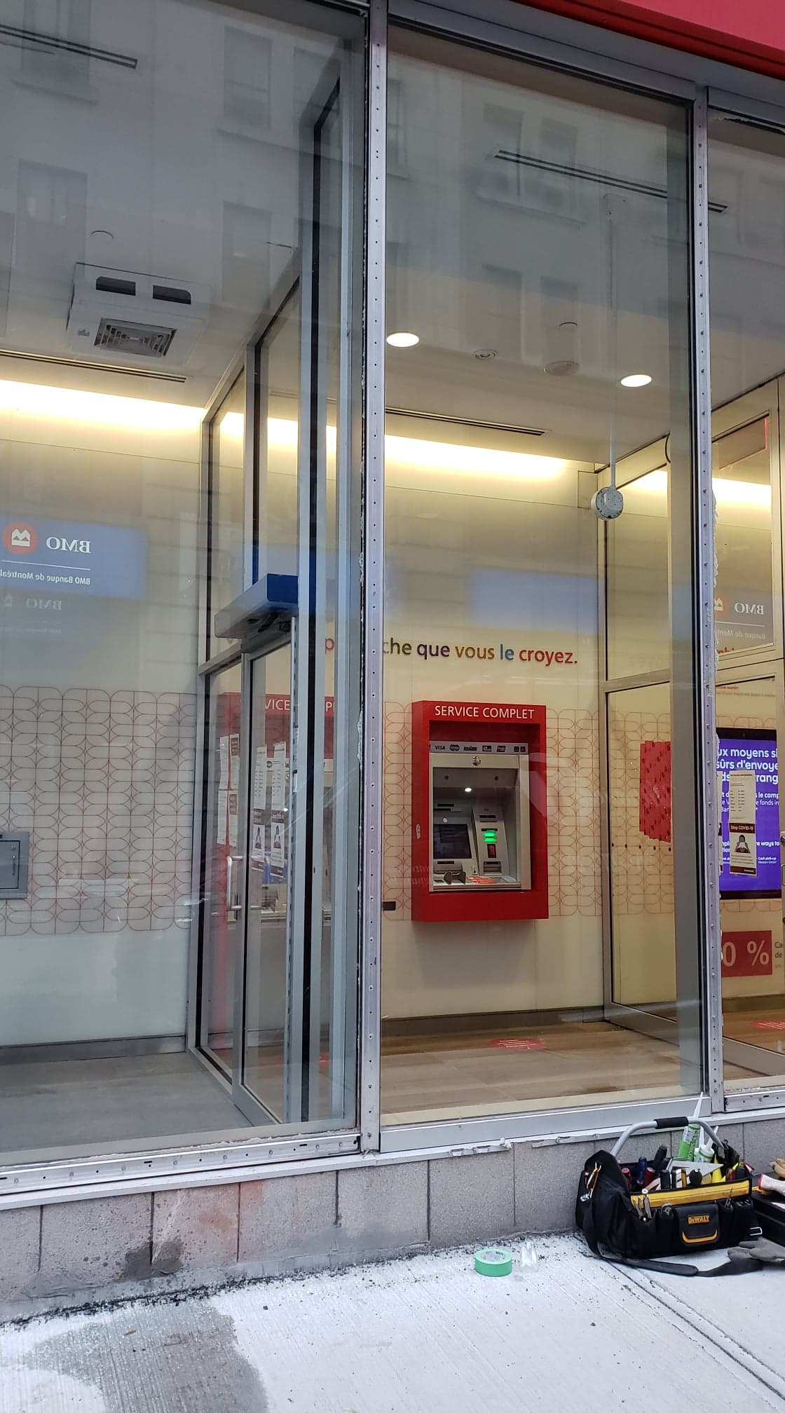 Il y a un distributeur automatique de billets rouge dans la fenêtre d'une banque.