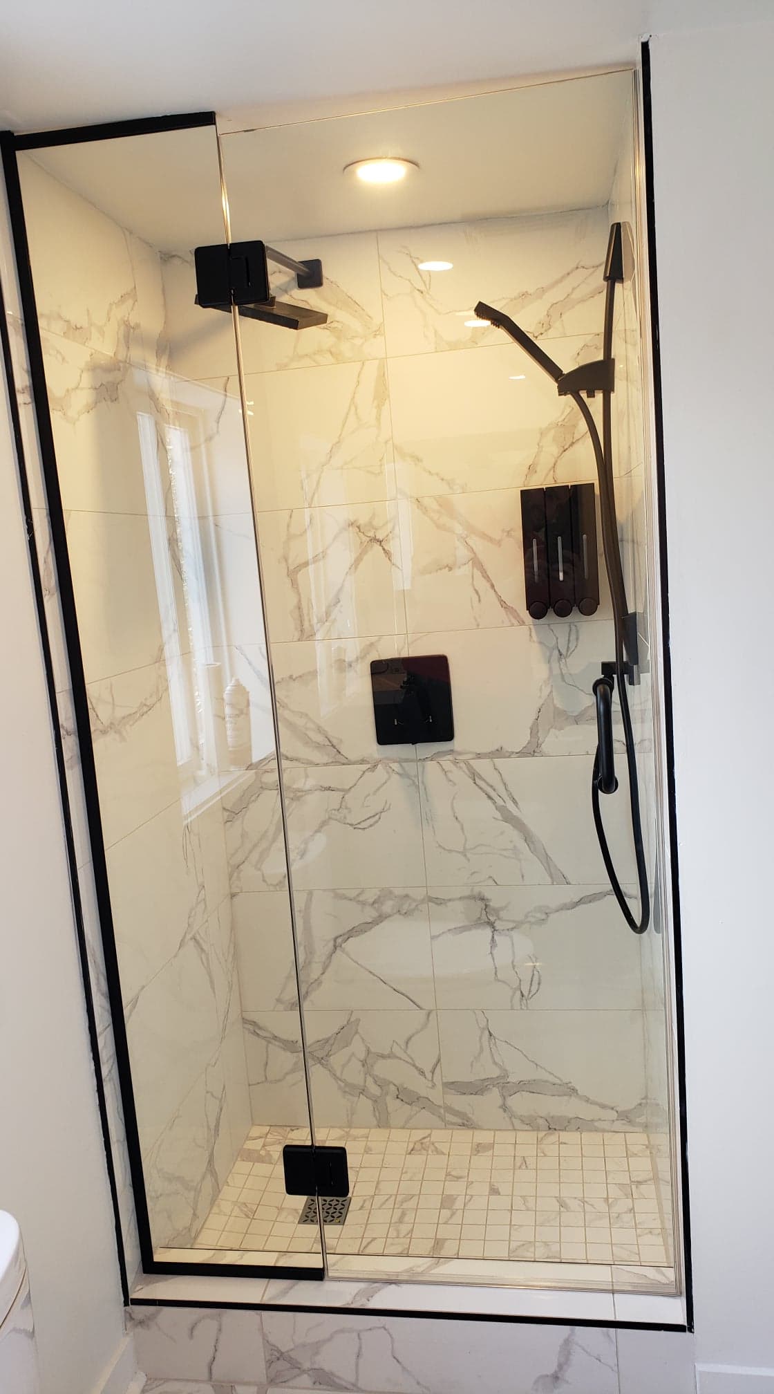 Une salle de bain avec douche à l'italienne avec porte vitrée.