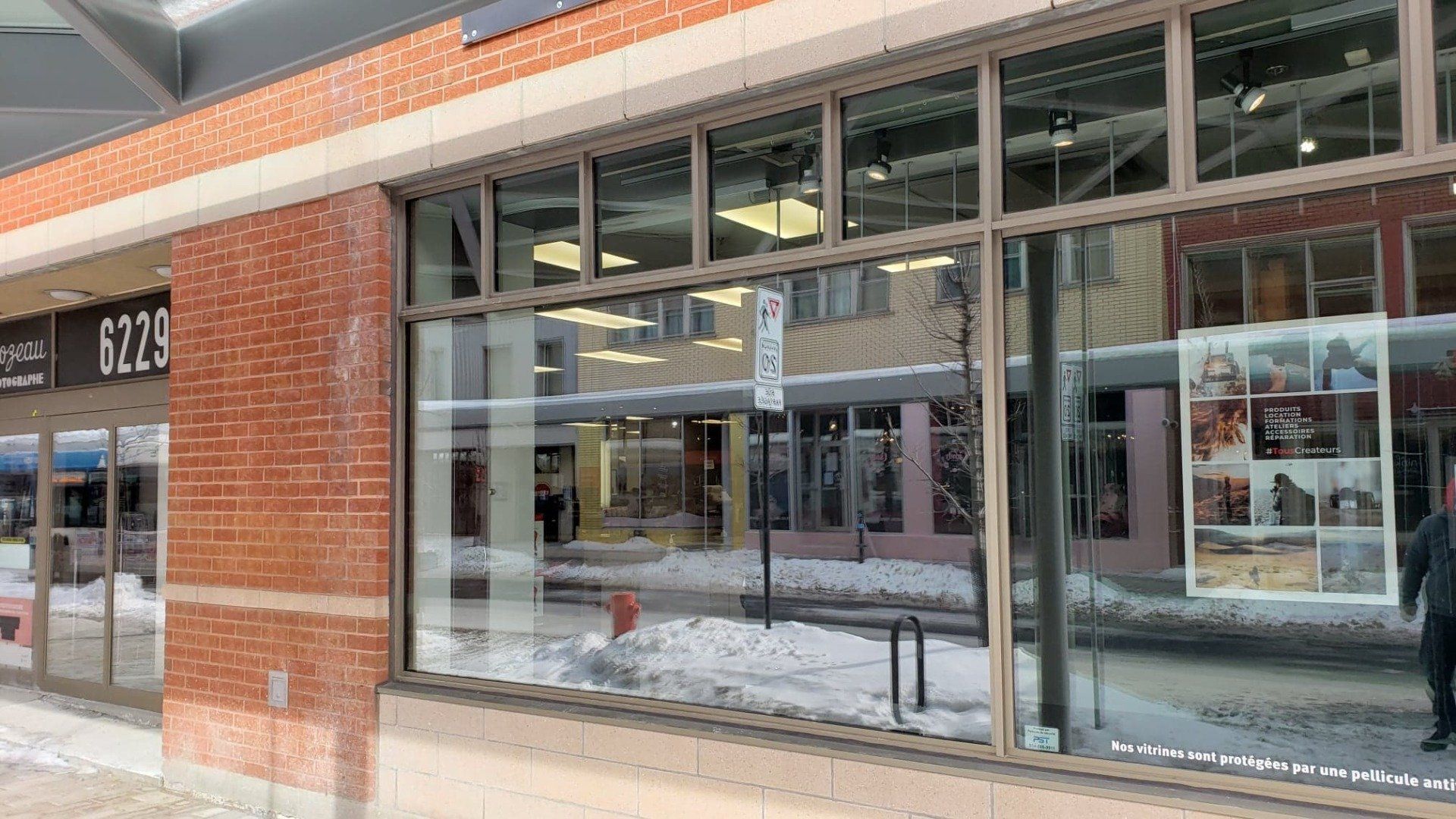Un bâtiment en briques avec beaucoup de fenêtres un jour de neige.