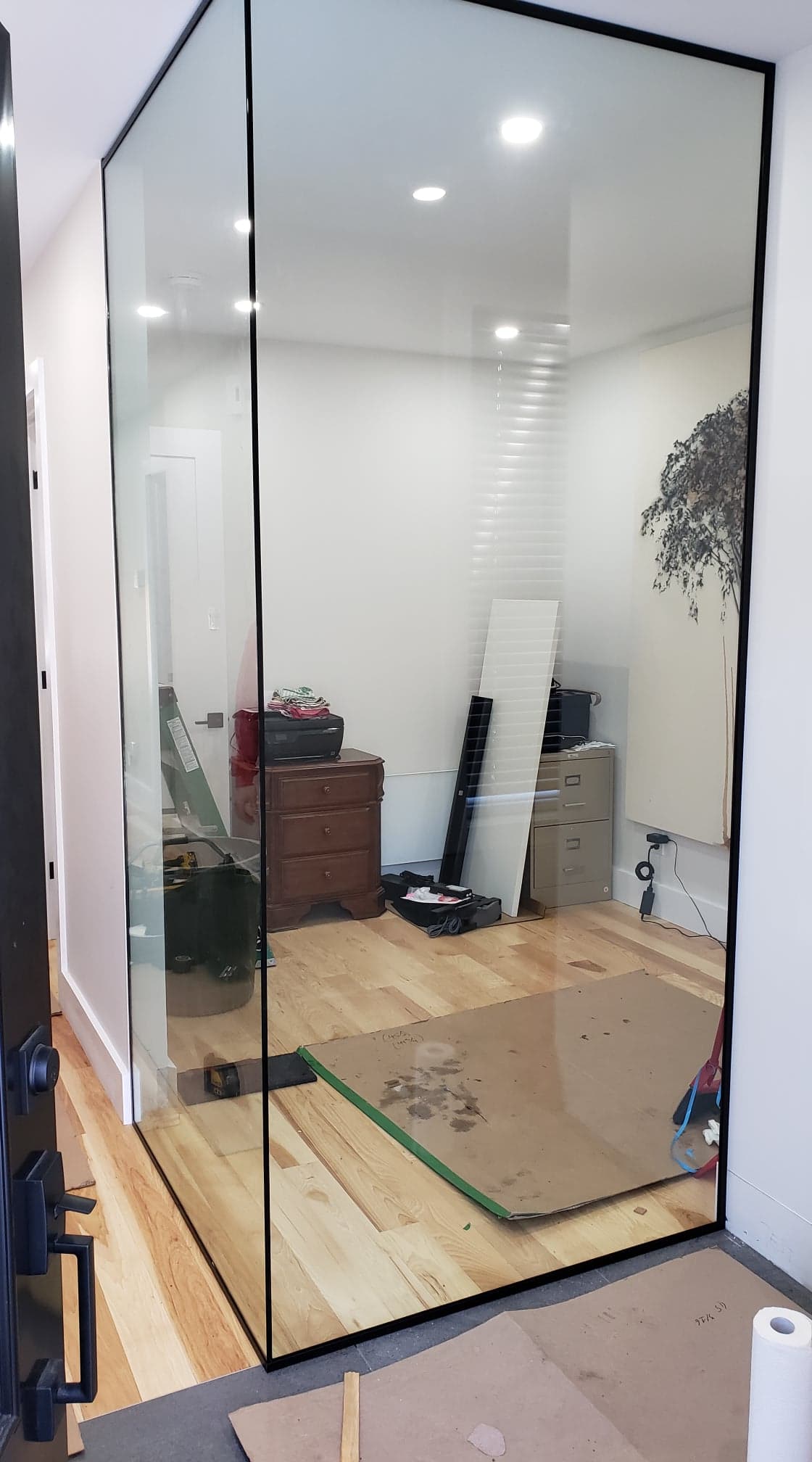 Une pièce avec un mur en verre et un plancher en bois.