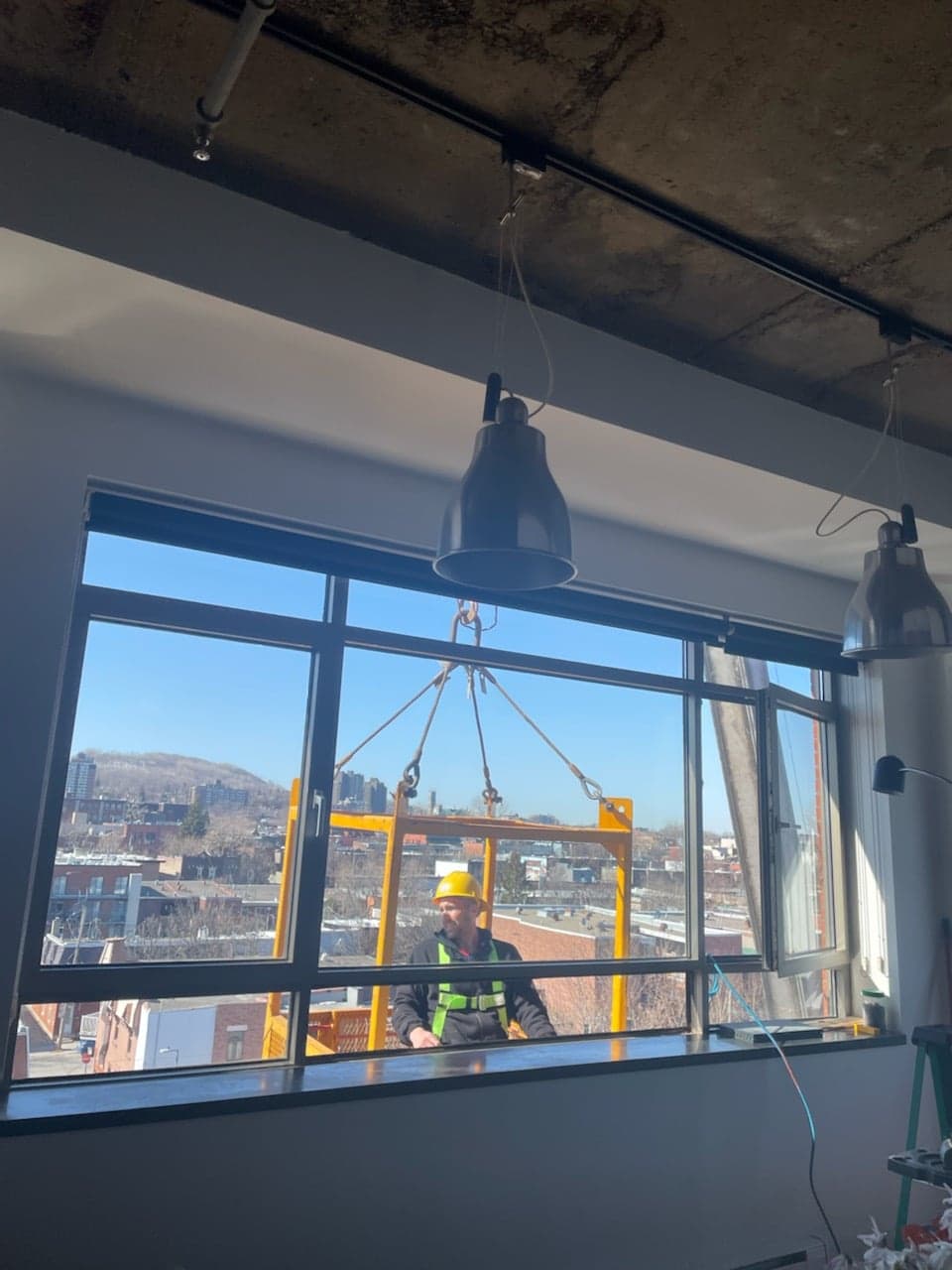 Un homme portant un casque de sécurité se tient devant une fenêtre