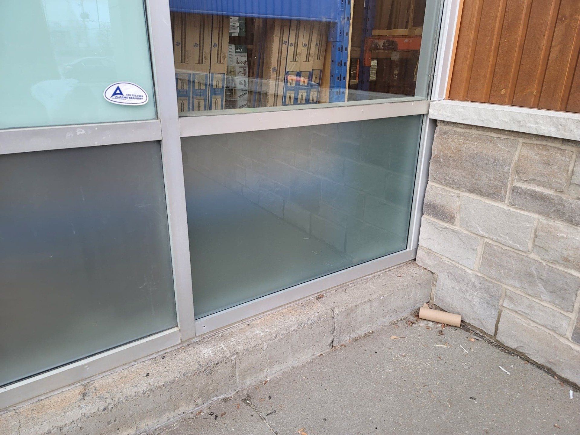 Une fenêtre avec un autocollant dessus se trouve sur le côté d'un bâtiment.