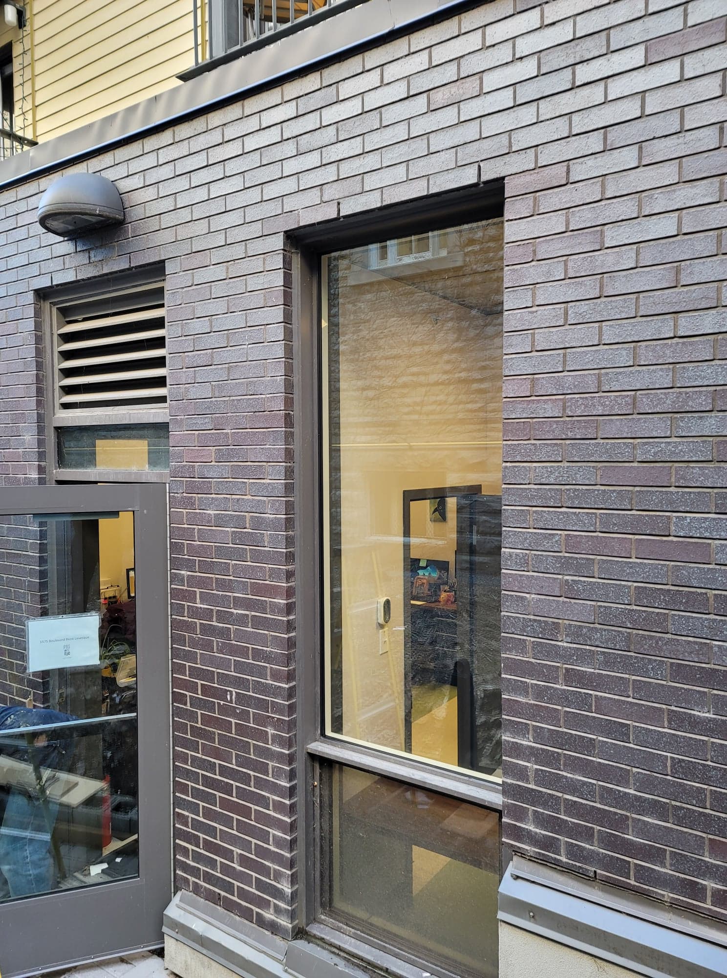 Un bâtiment en briques avec une porte et une fenêtre.