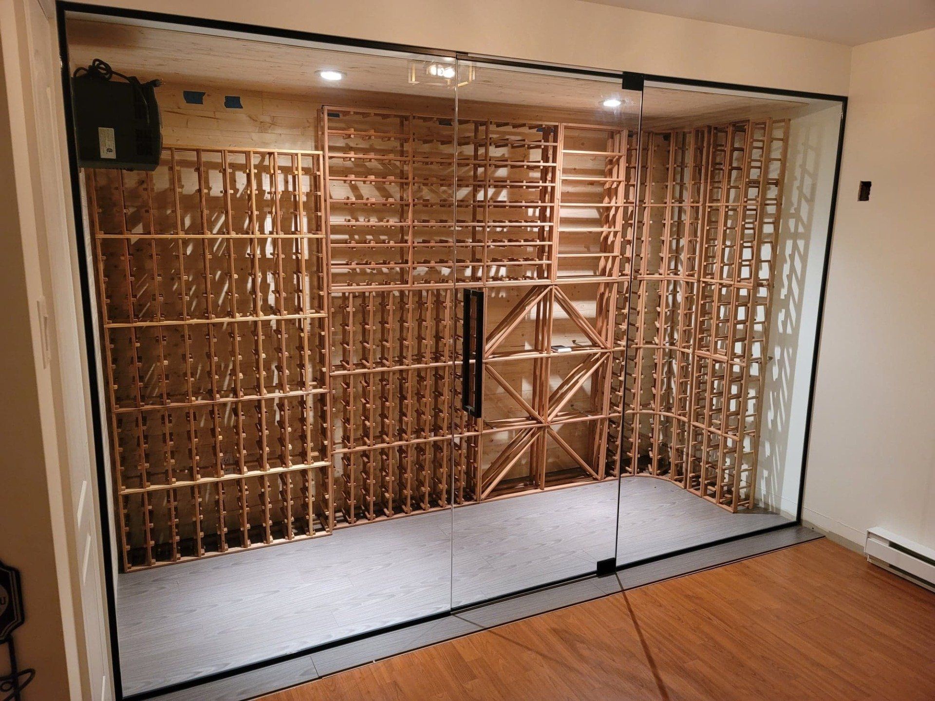 Une cave à vin avec des étagères en bois et des portes vitrées