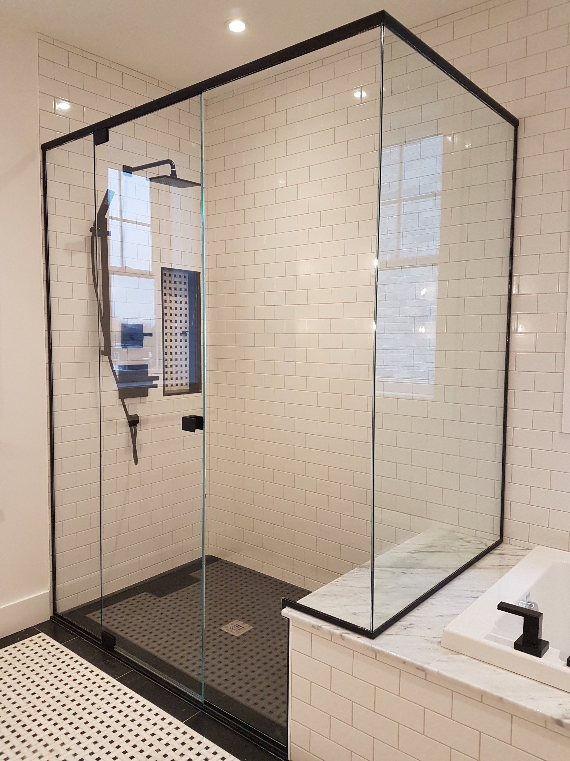 Une salle de bain avec une douche à l'italienne avec un cadre noir.