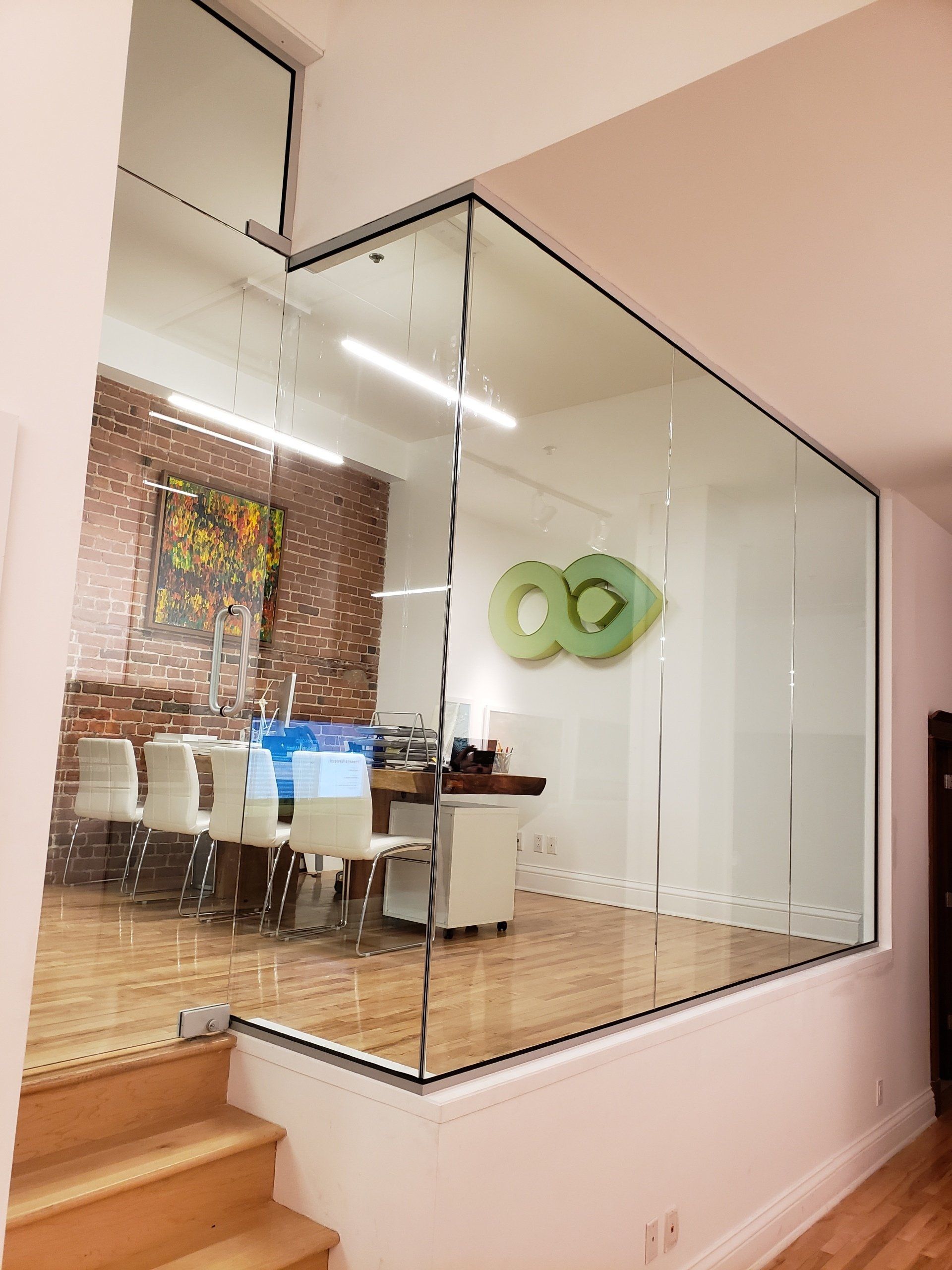 Une pièce avec un mur en verre et des escaliers qui y mènent.