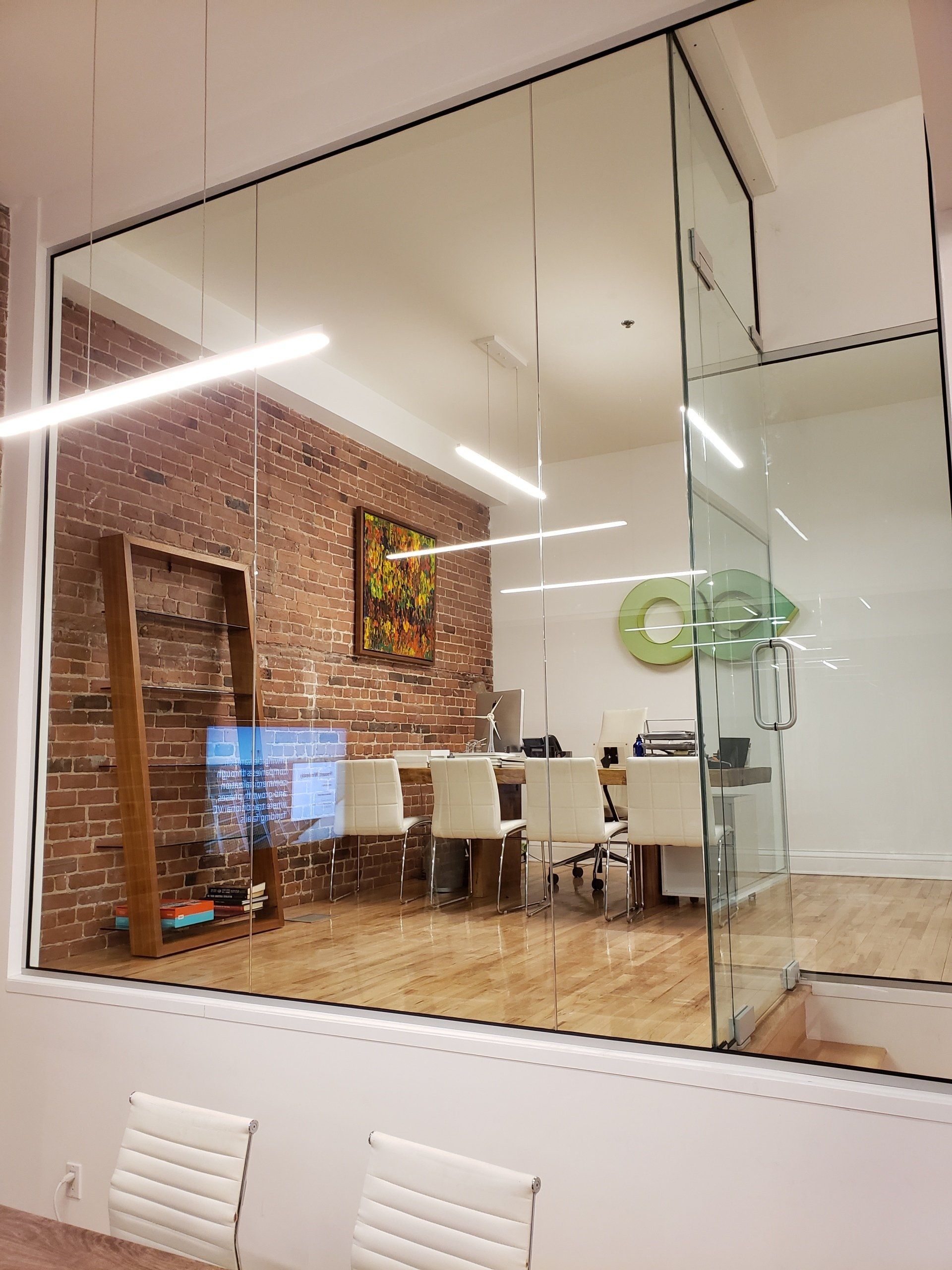 Une salle de conférence avec un mur de verre et un mur de briques.