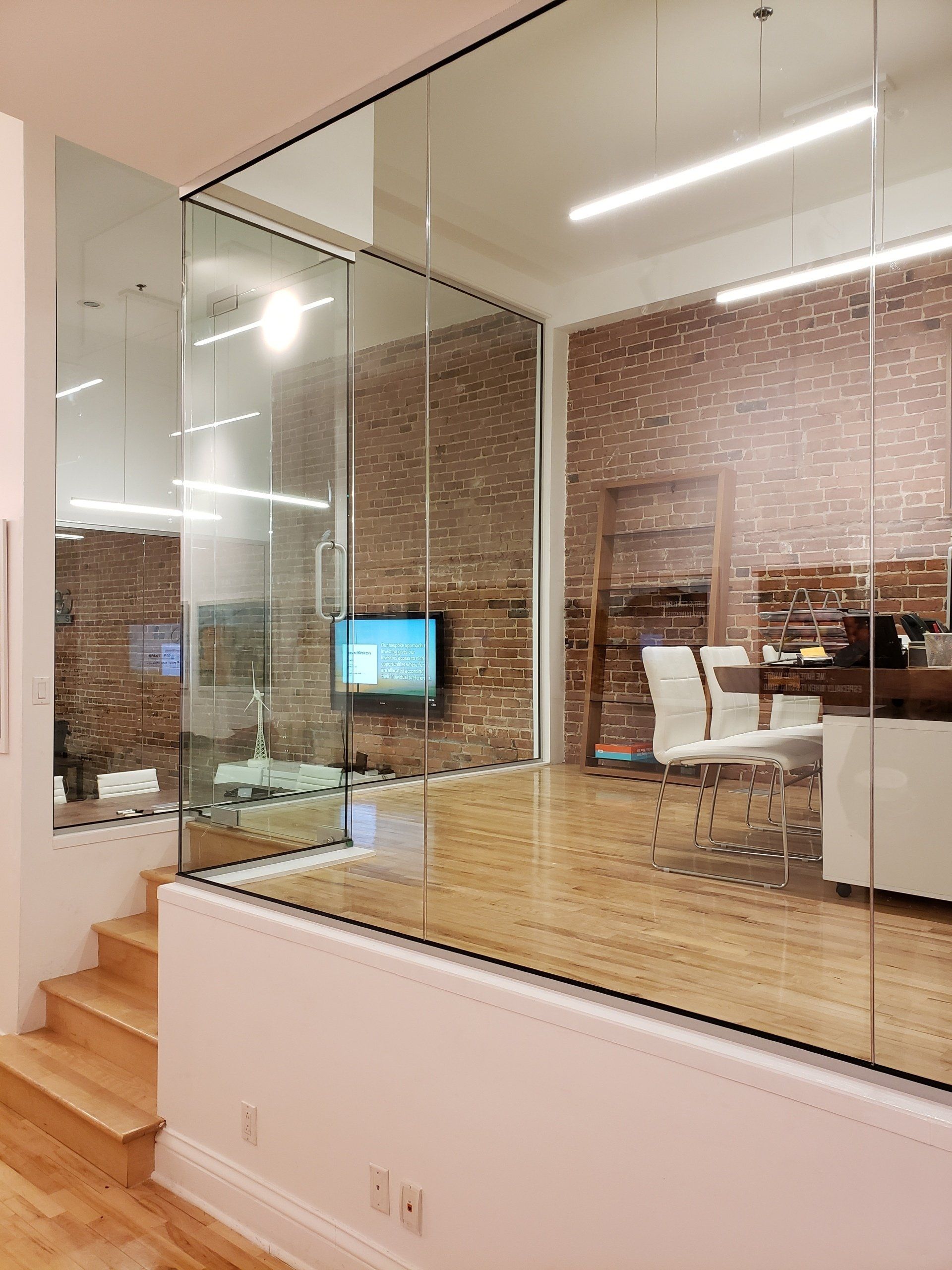 Une pièce avec un mur de verre et un mur de briques.