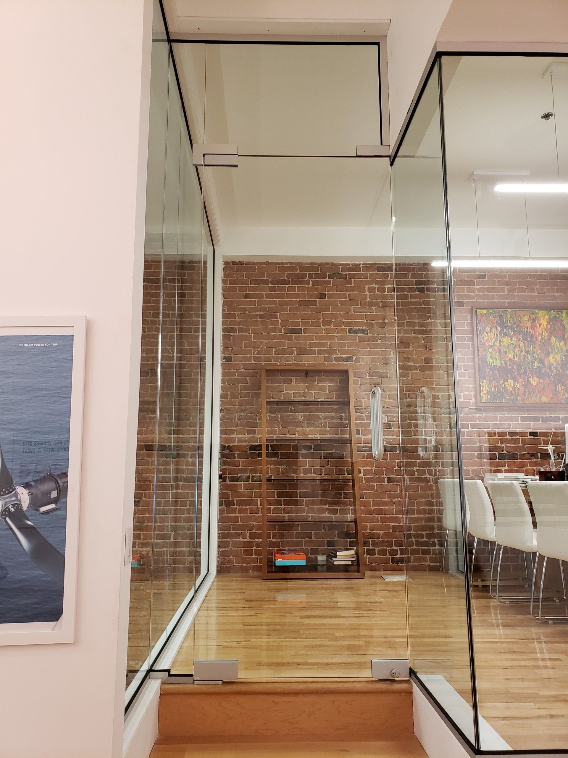 Une pièce avec un mur de briques et un tableau sur le mur.