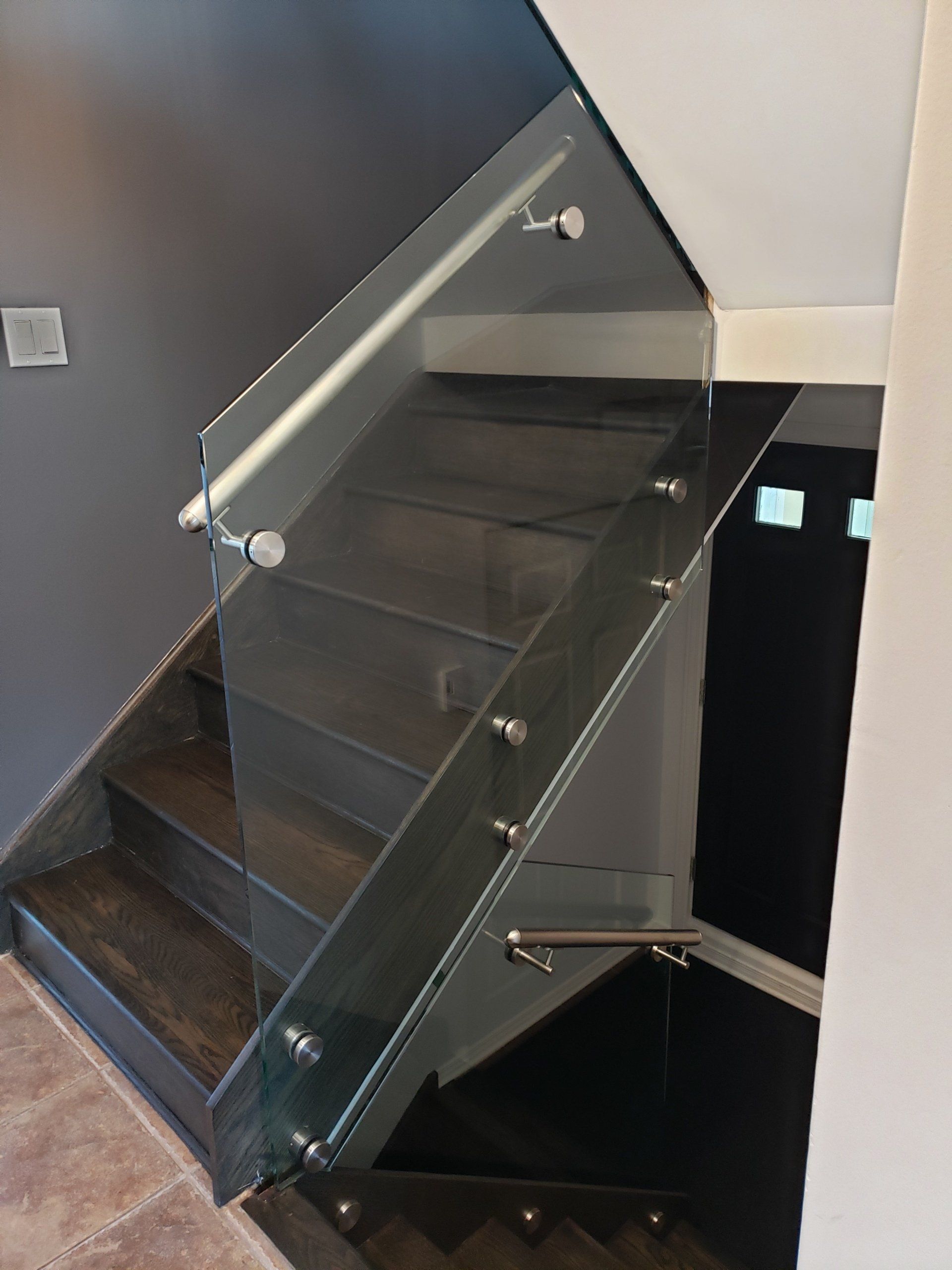 Un escalier avec une rampe et des marches en verre transparent