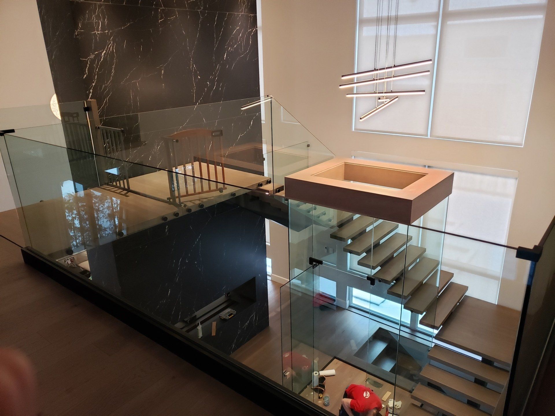 Un escalier avec une rampe en verre et un lavabo au milieu