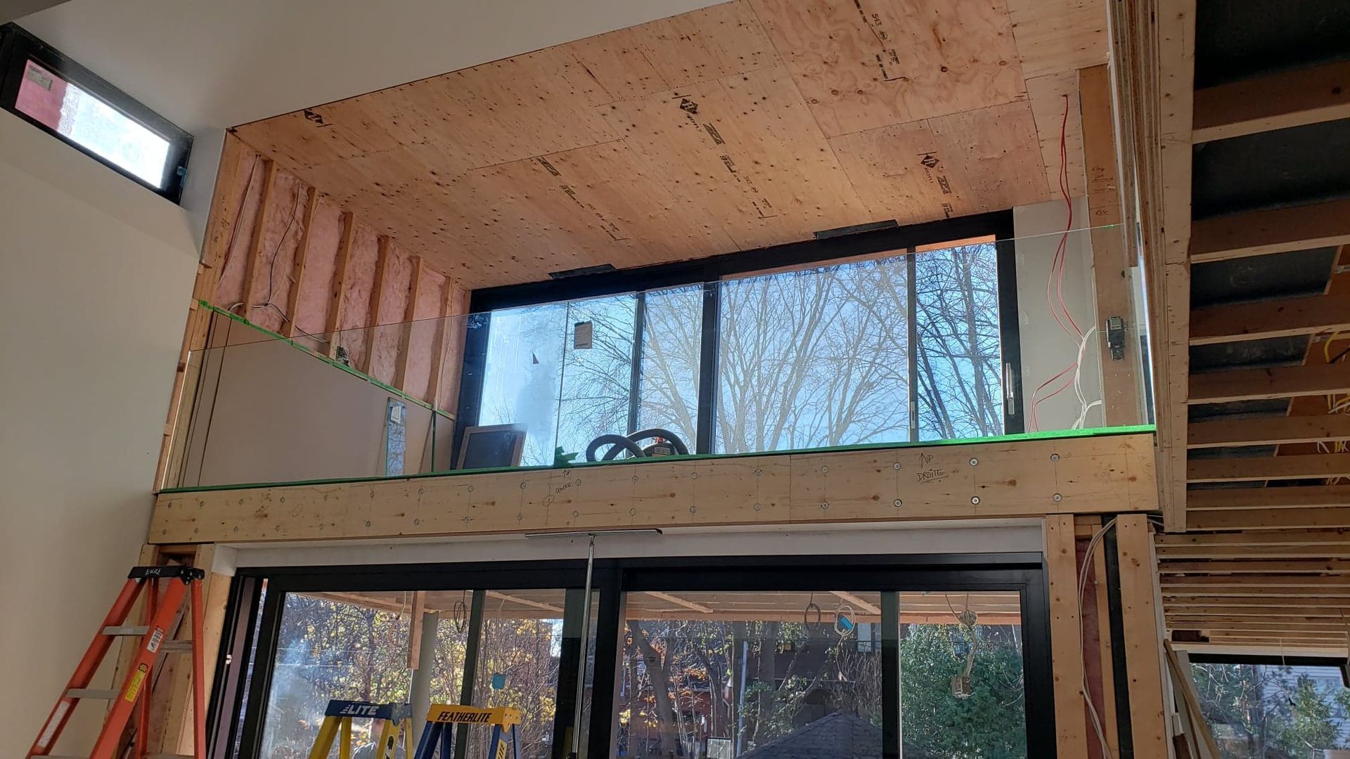 Une pièce avec beaucoup de fenêtres et une échelle à l'intérieur.