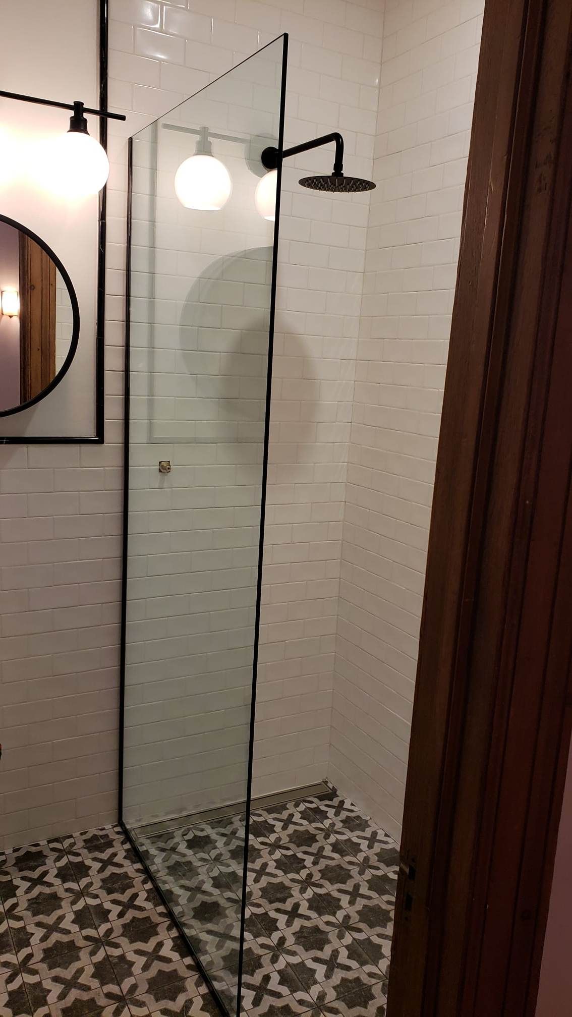 Une salle de bain avec douche à l'italienne et miroir.