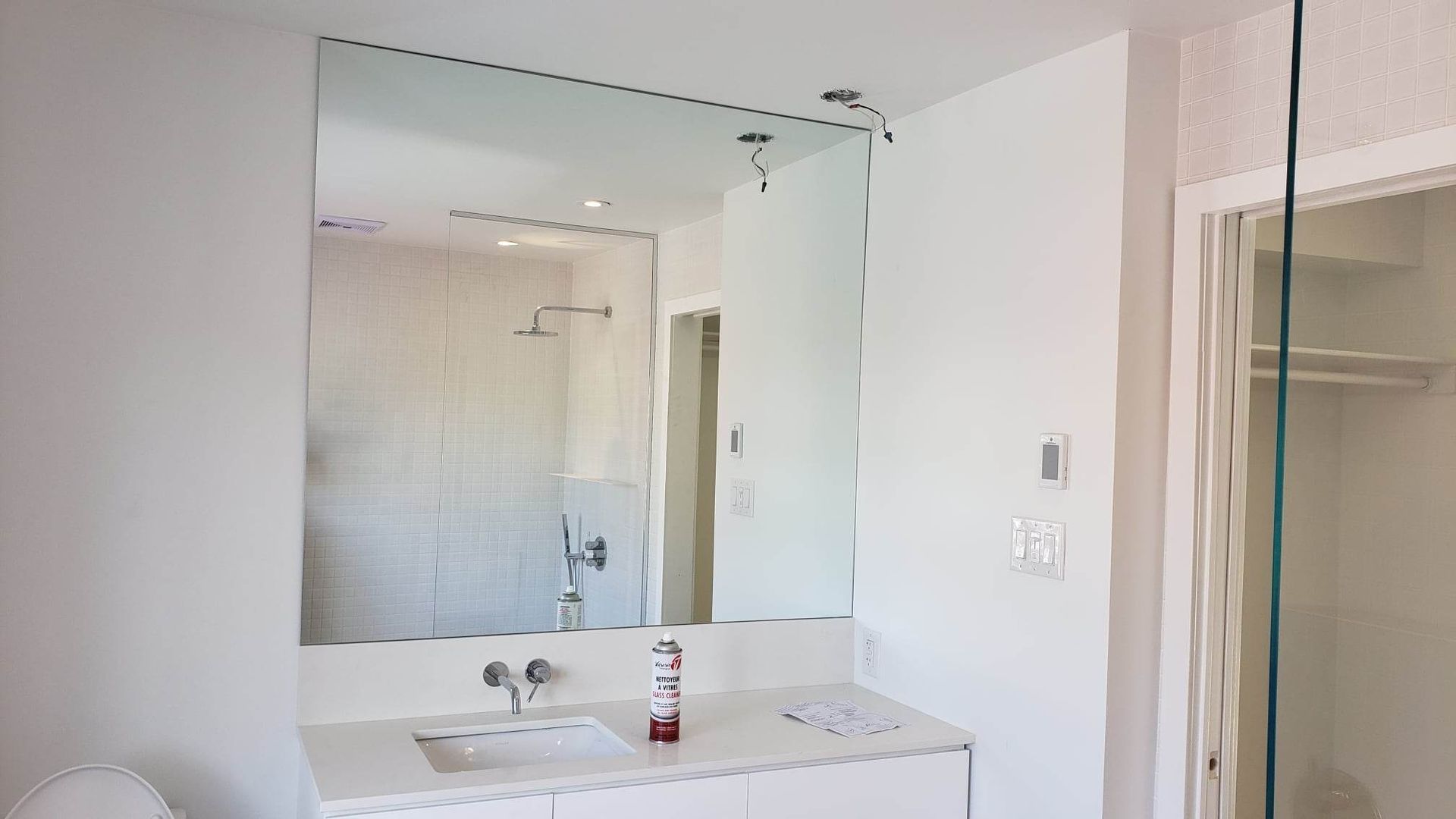 Une salle de bain avec lavabo, miroir et douche.