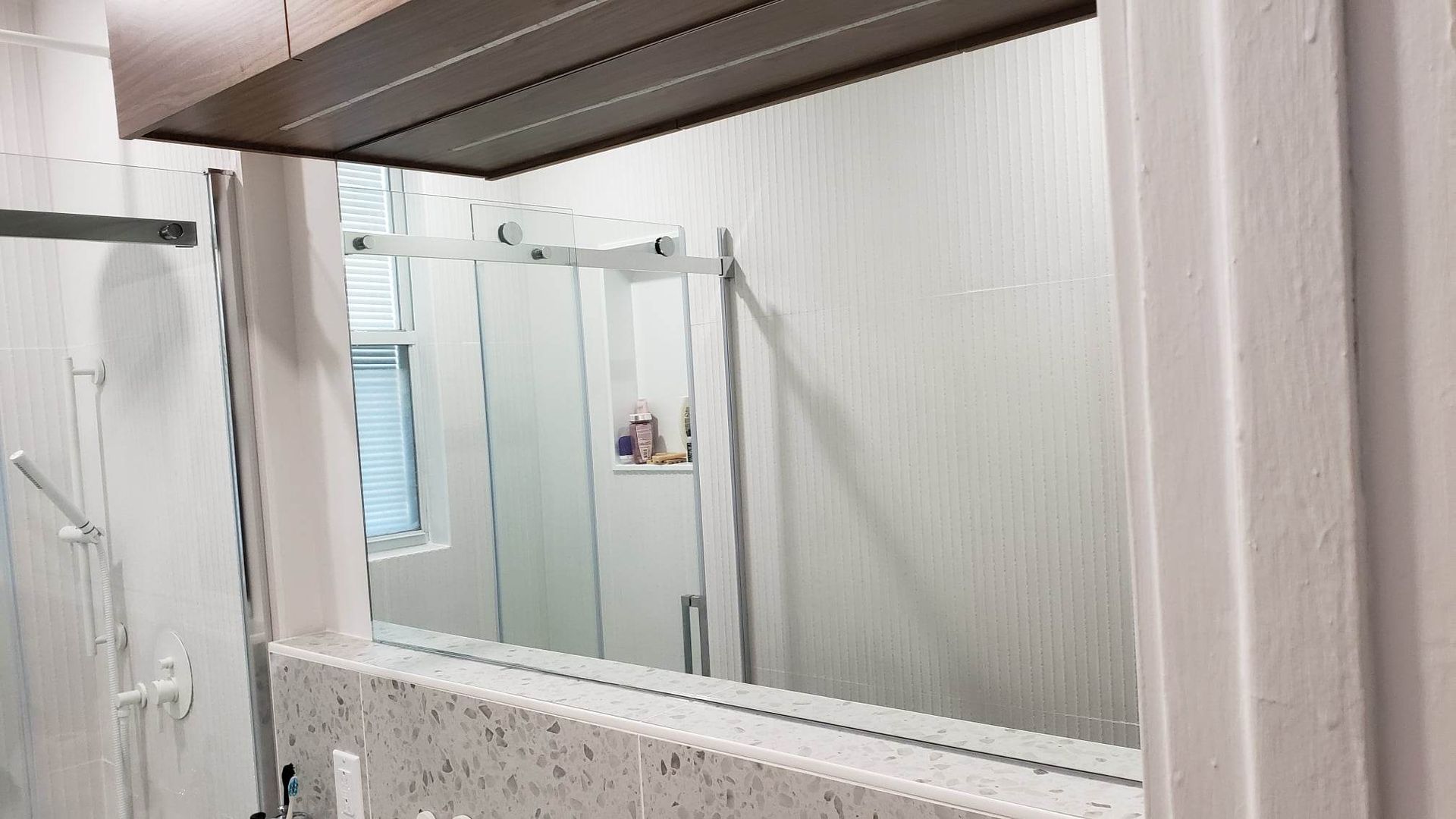 Une salle de bain avec un grand miroir et une cabine de douche.