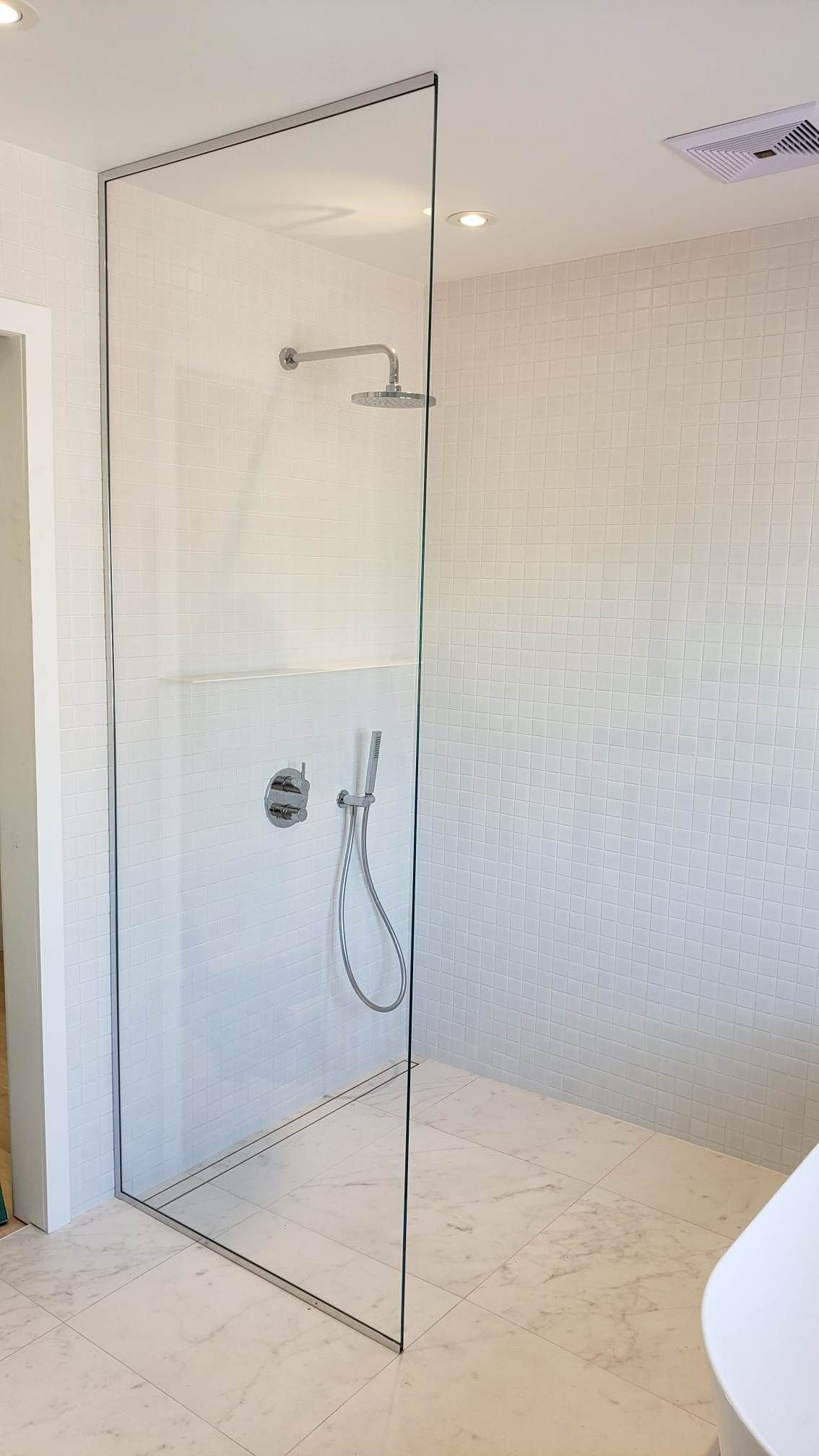 Une salle de bain avec une douche à l'italienne et une baignoire.