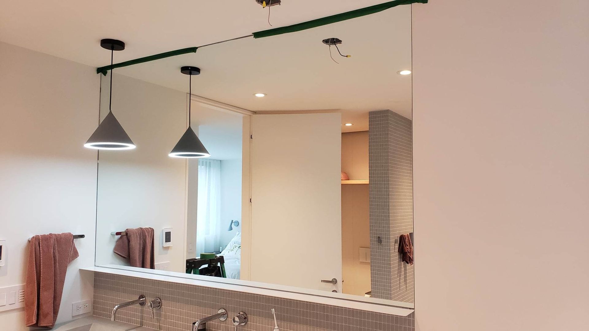 Une salle de bain avec un grand miroir et un lavabo.