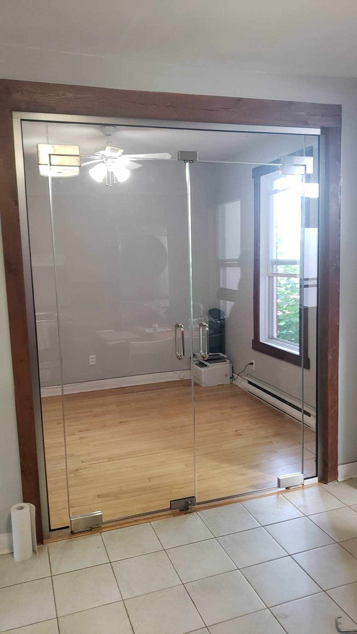 Une pièce avec un plancher en bois et une porte vitrée.