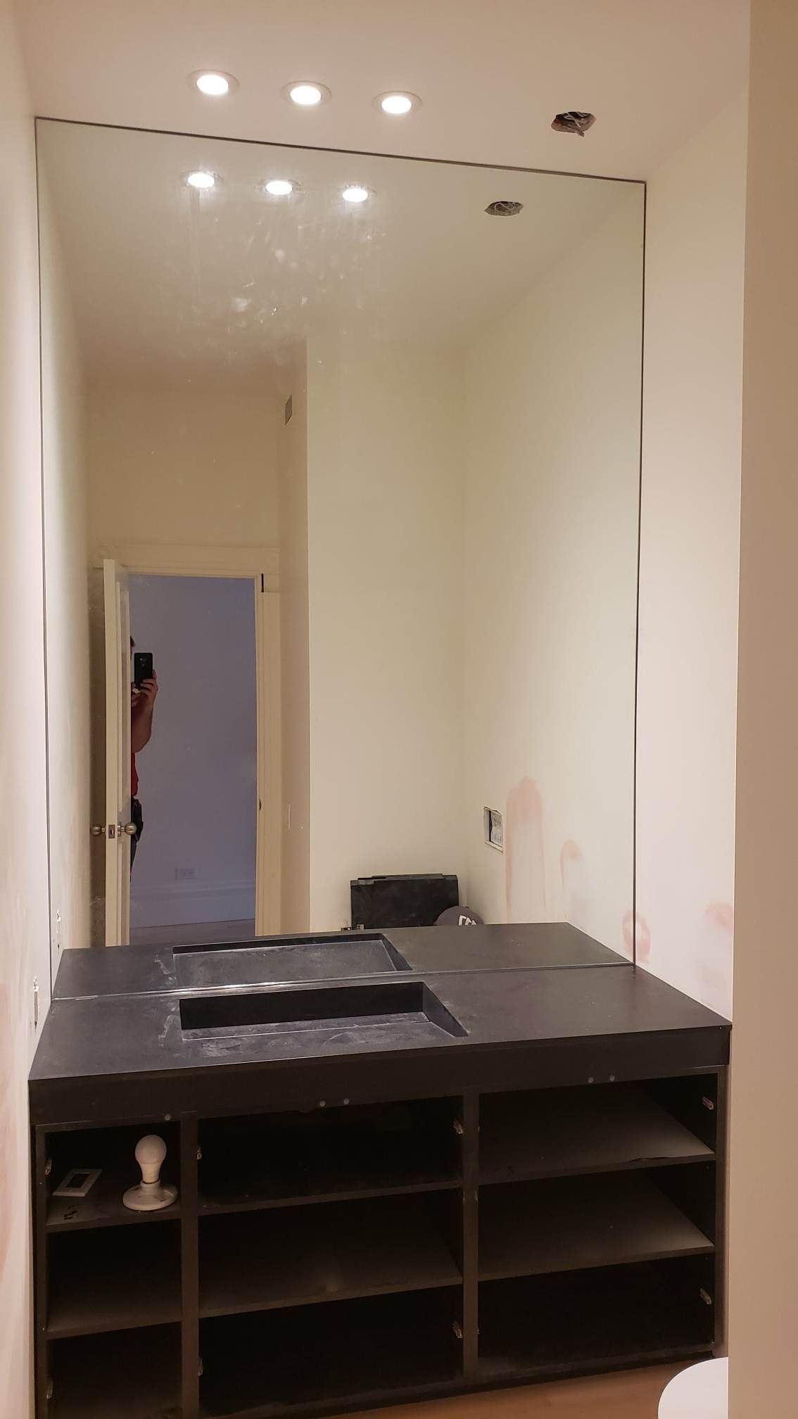 Une salle de bain avec un lavabo et un grand miroir.