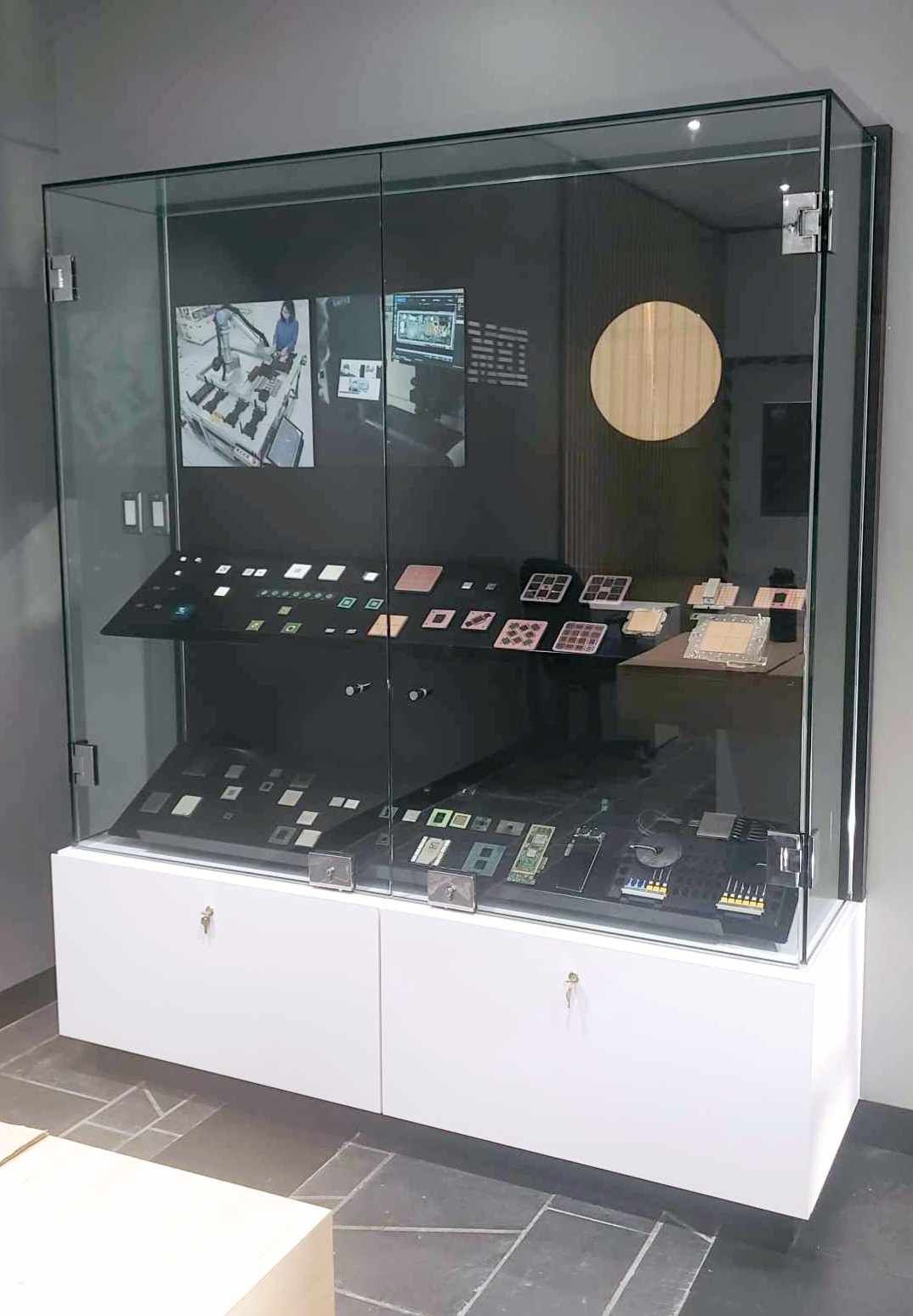 A glass display case filled with various items in a room.
