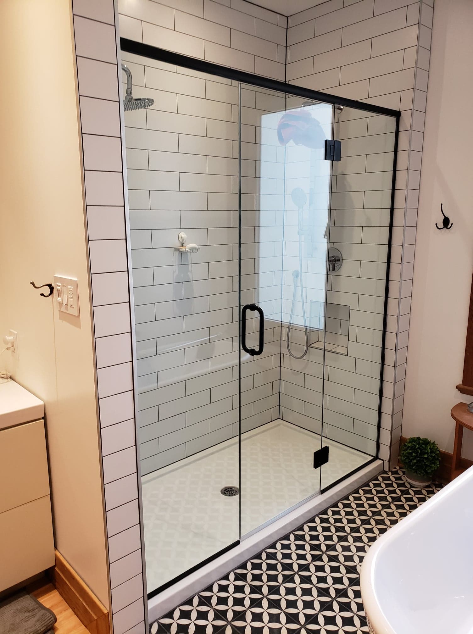 Une salle de bain avec carrelage blanc et une porte de douche coulissante en verre.