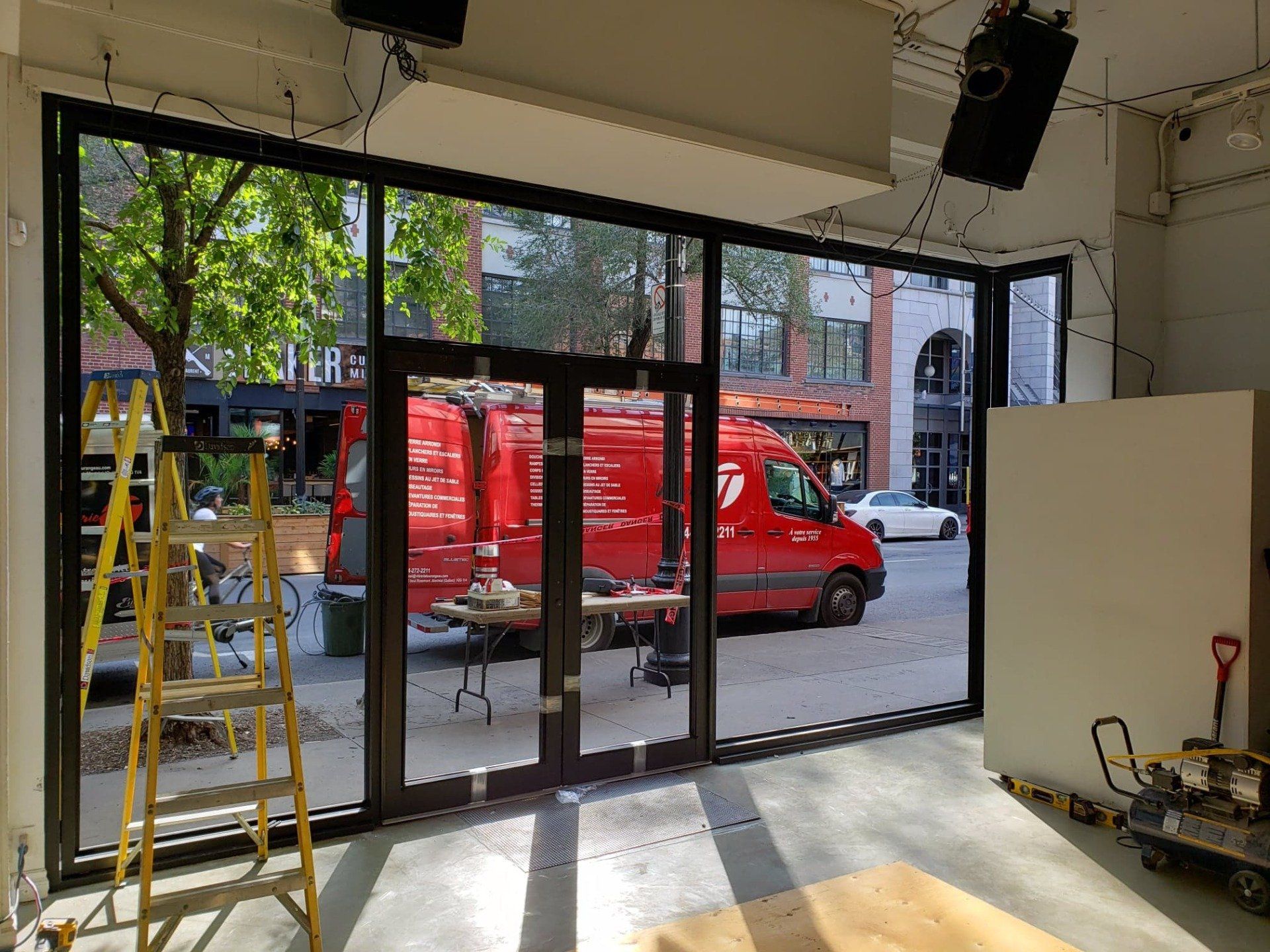 A large room with a lot of windows and a red van in the background.