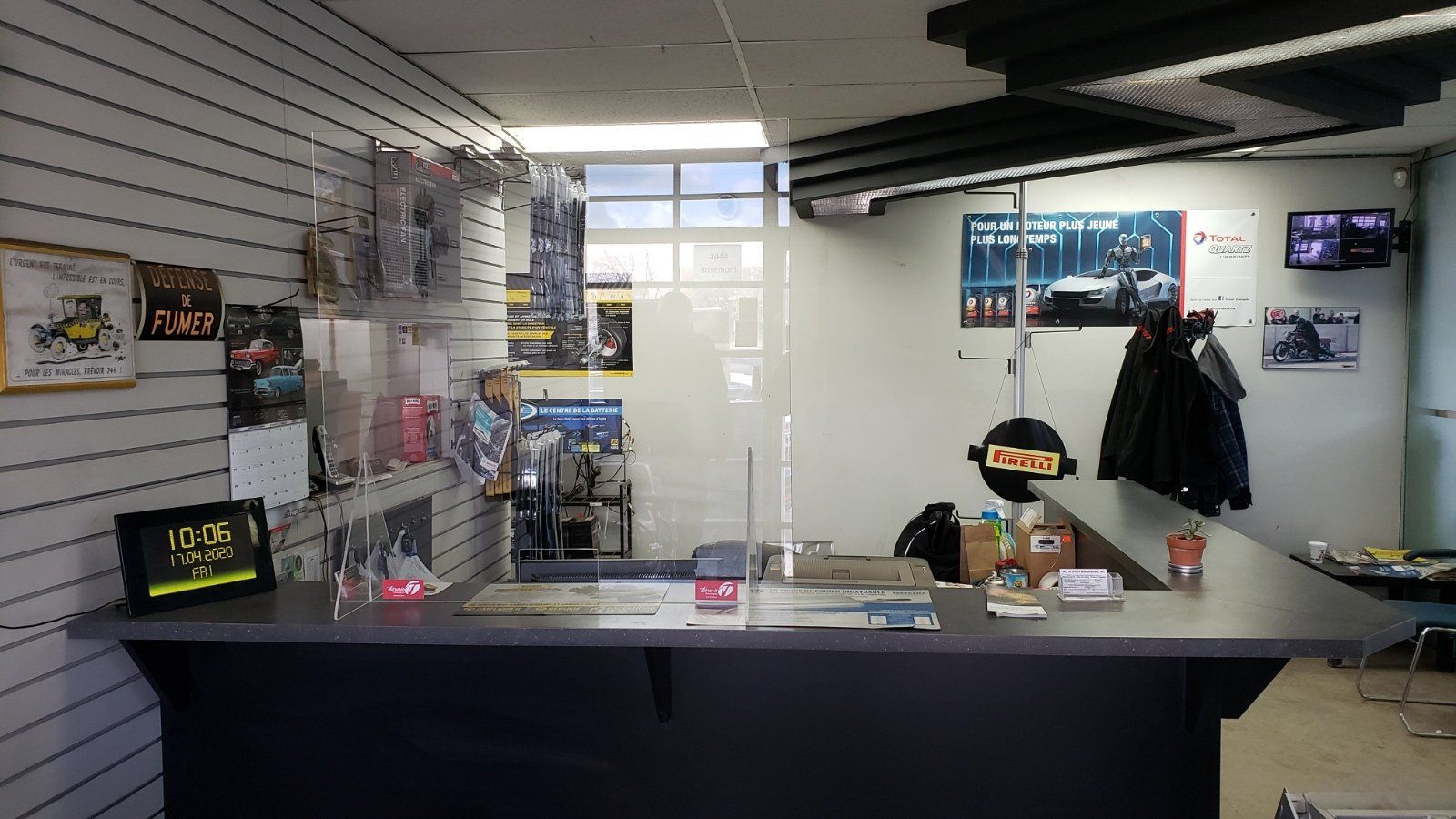 Un comptoir dans un magasin avec une barrière transparente entre lui et le comptoir.