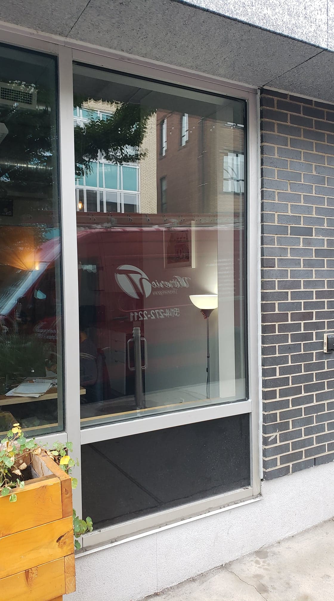 Une grande fenêtre sur le côté d'un bâtiment avec un mur de briques.