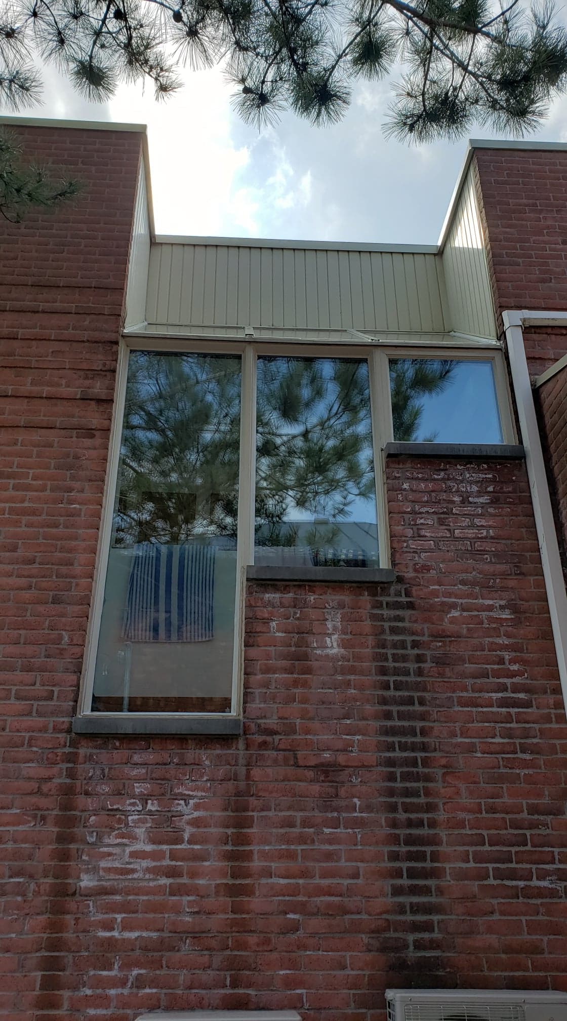 Un bâtiment en briques avec une grande fenêtre sur le côté.