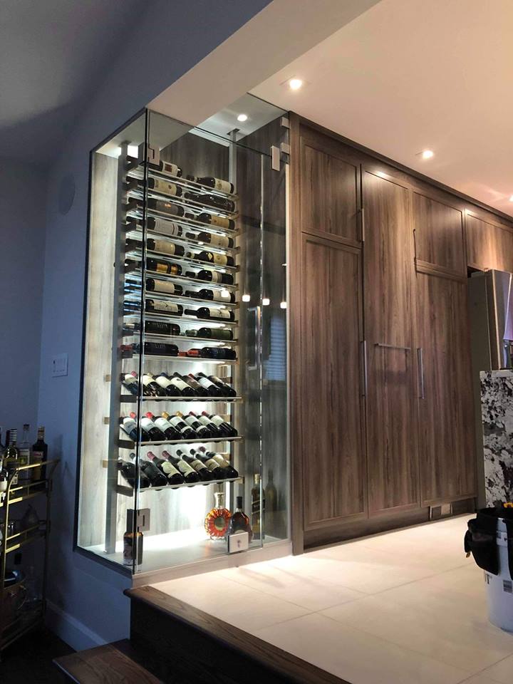 Une cave à vin remplie de nombreuses bouteilles de vin dans une cuisine.