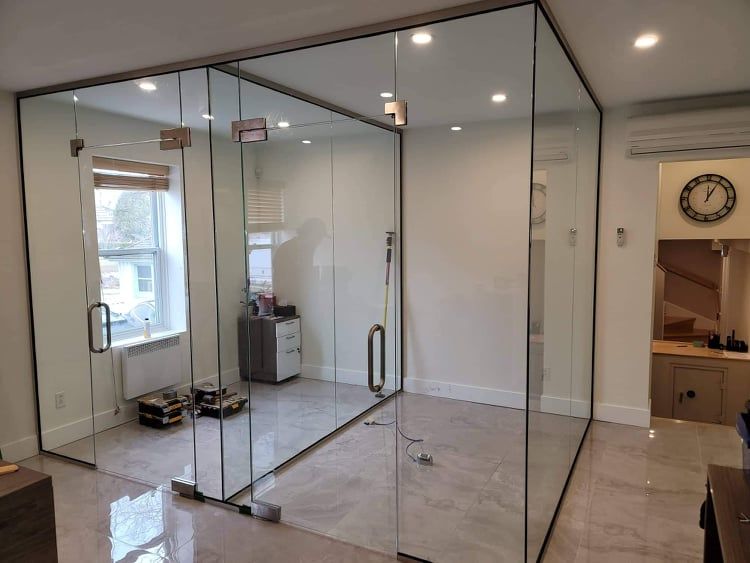 Une pièce avec beaucoup de portes vitrées et une horloge sur le mur.