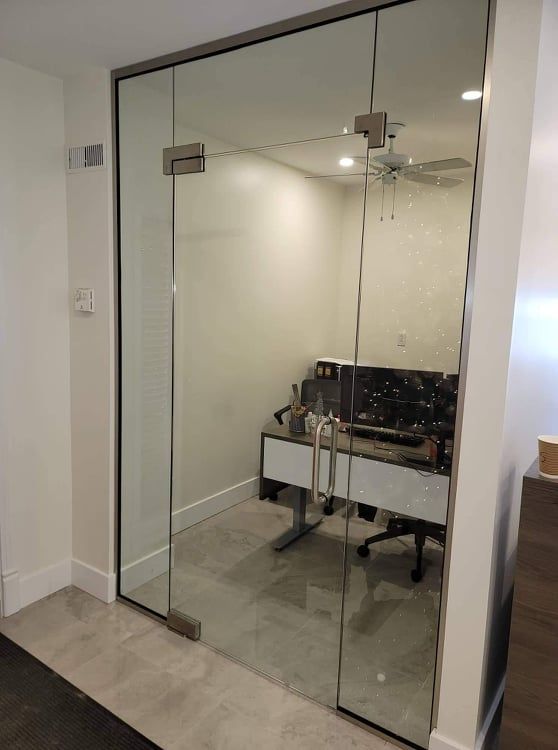 Une pièce avec un mur en verre et un bureau à l'intérieur