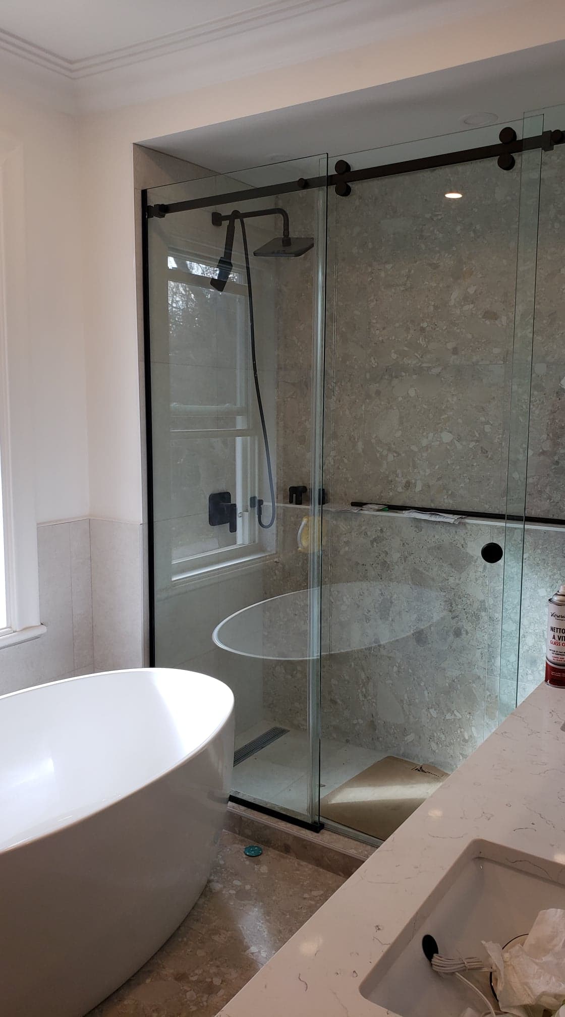 Une salle de bain avec baignoire, lavabo, douche et porte coulissante en verre.