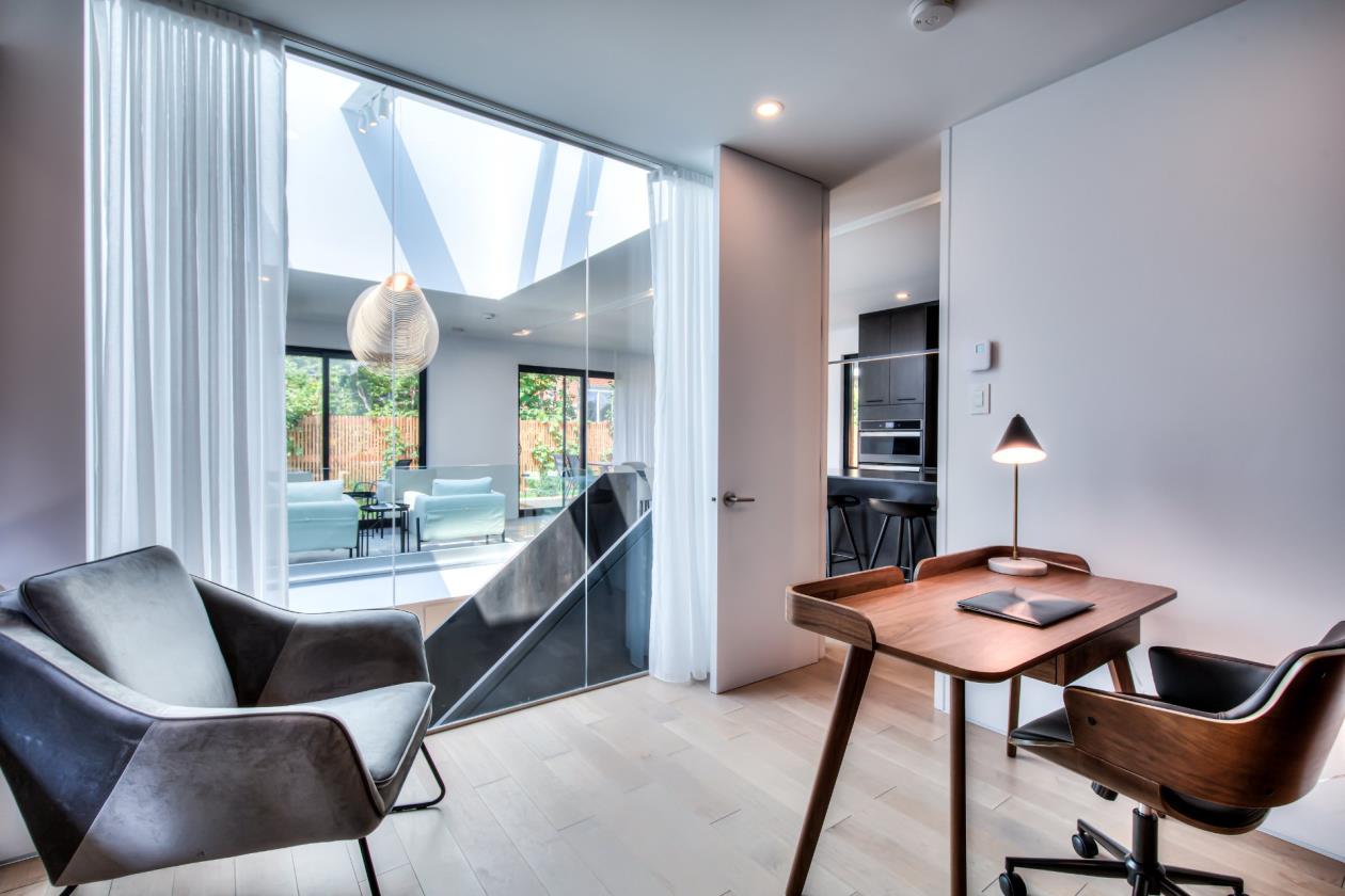 Une pièce avec un bureau et des chaises et une grande fenêtre