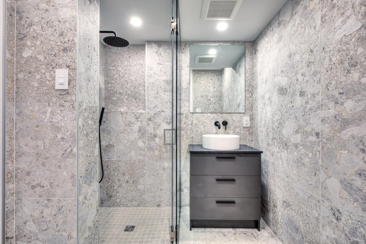 Une salle de bain avec douche à l'italienne, lavabo et miroir.