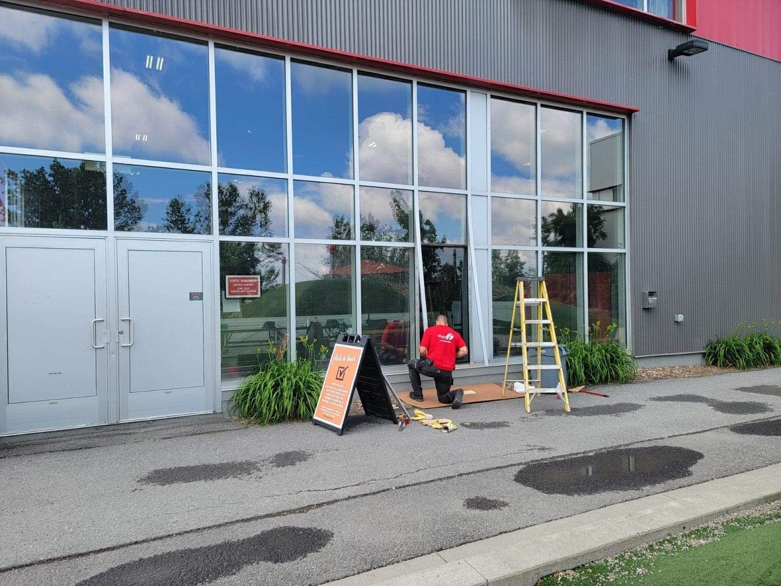 Un homme se tient devant un grand bâtiment.