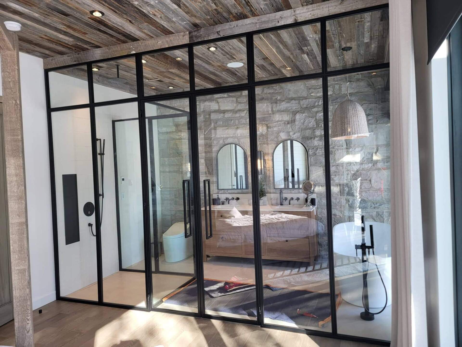 Une salle de bain avec une douche à l'italienne et une baignoire entourée de portes vitrées.